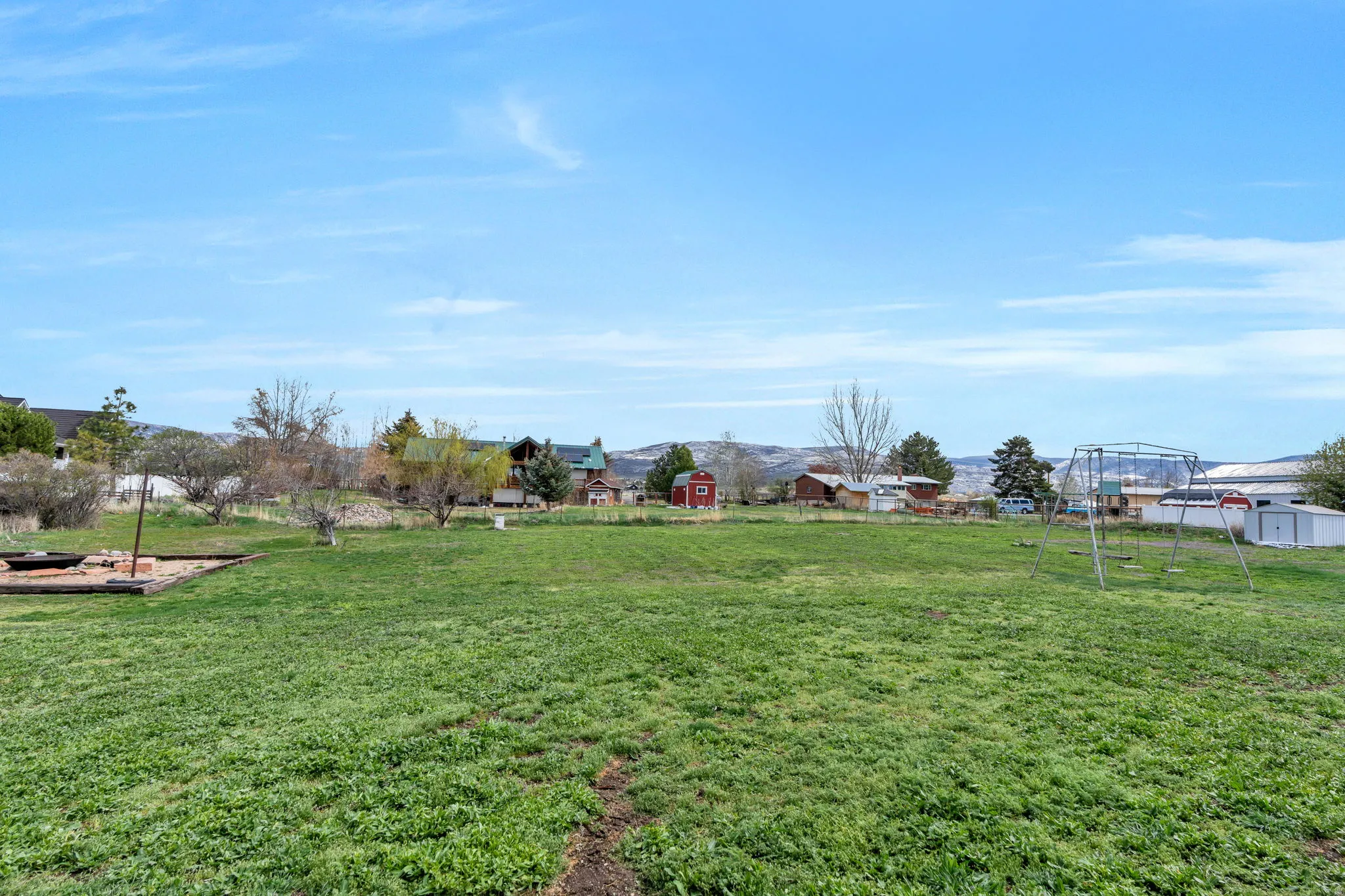 View of grassy yard featuring a storage shed and a mountain view