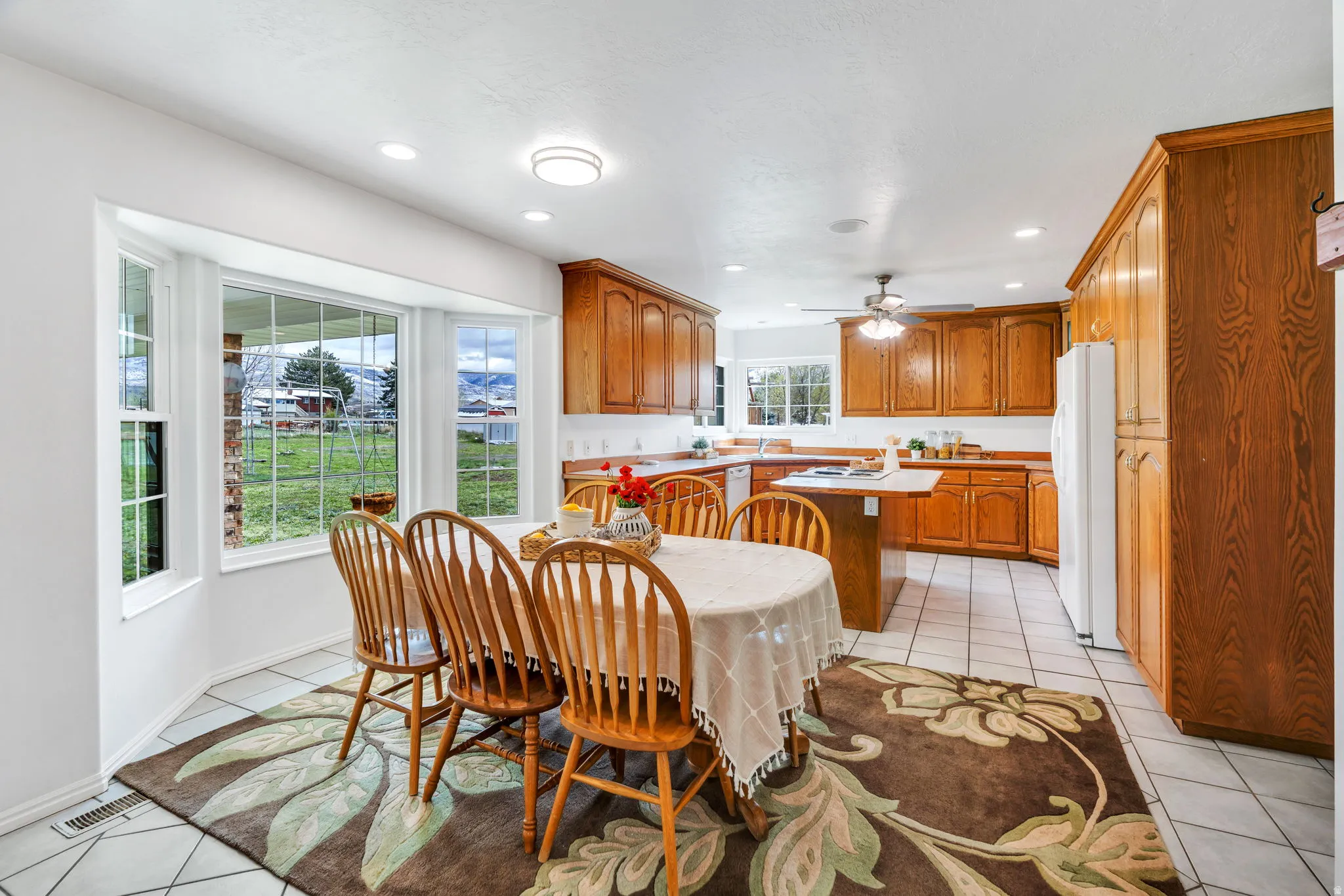 Dining area featuring light tile patterned flooring, recessed lighting, and ceiling fan