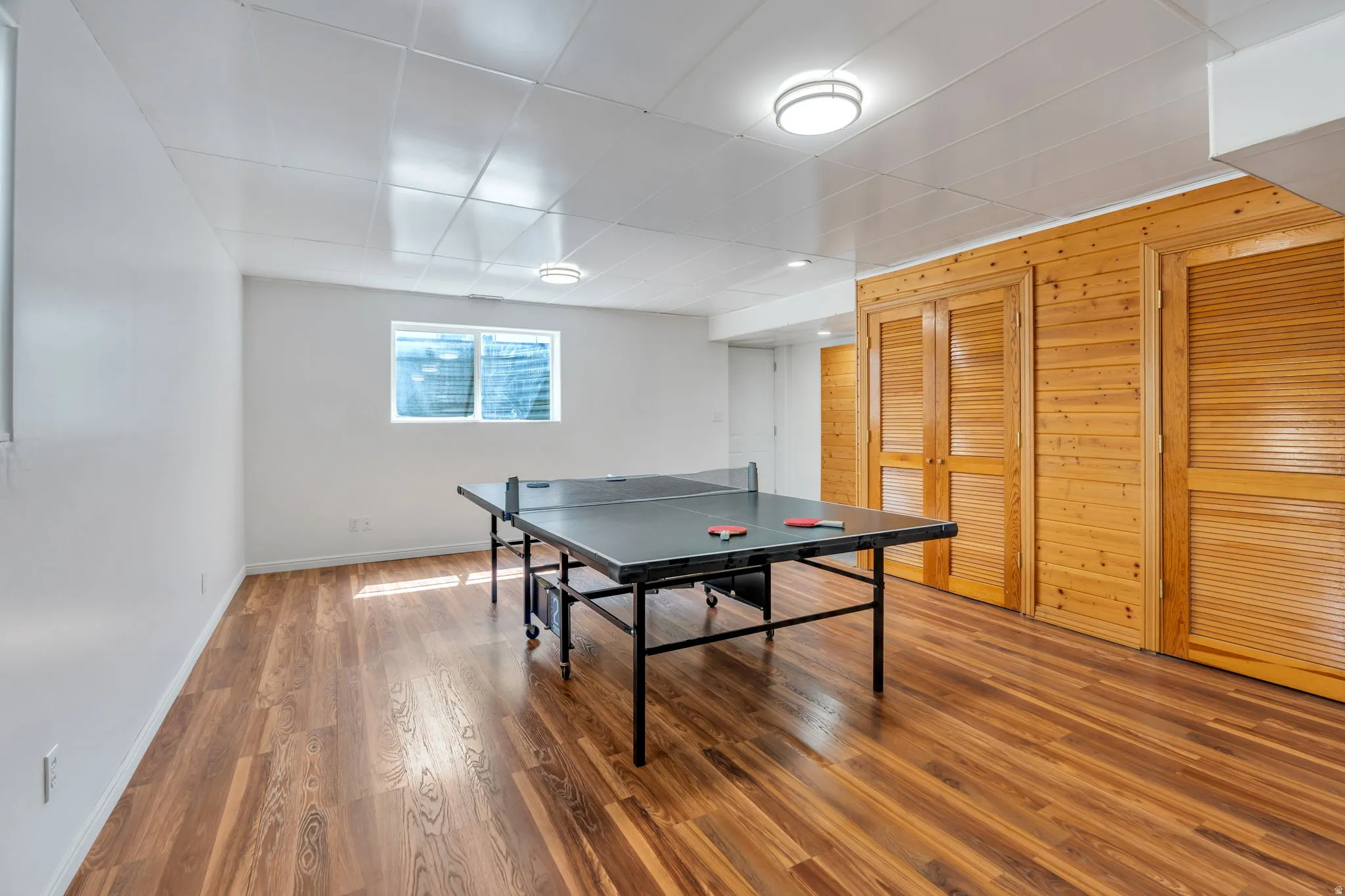Recreation room featuring wood walls and wood finished floors