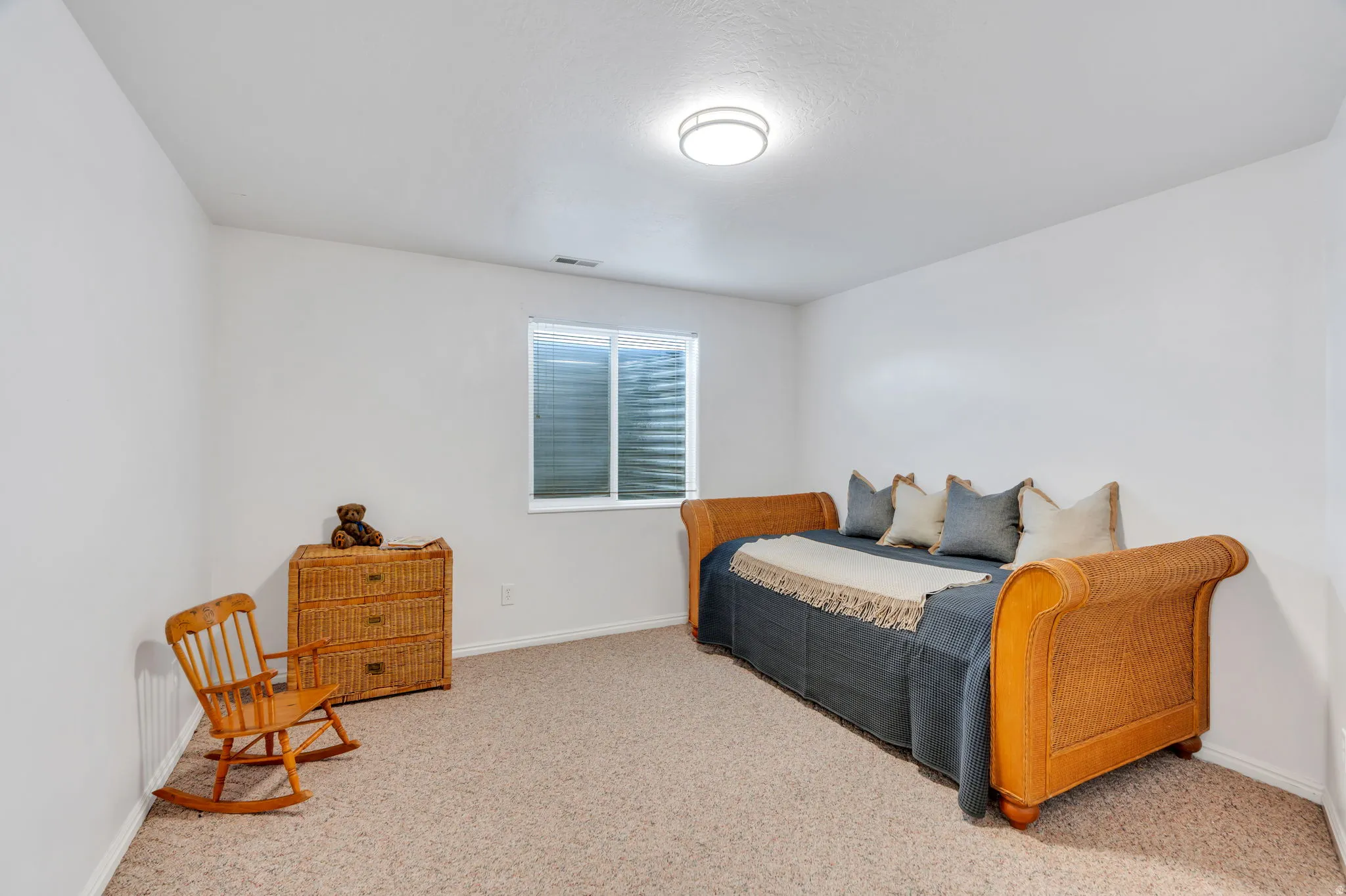 Bedroom with baseboards and light carpet
