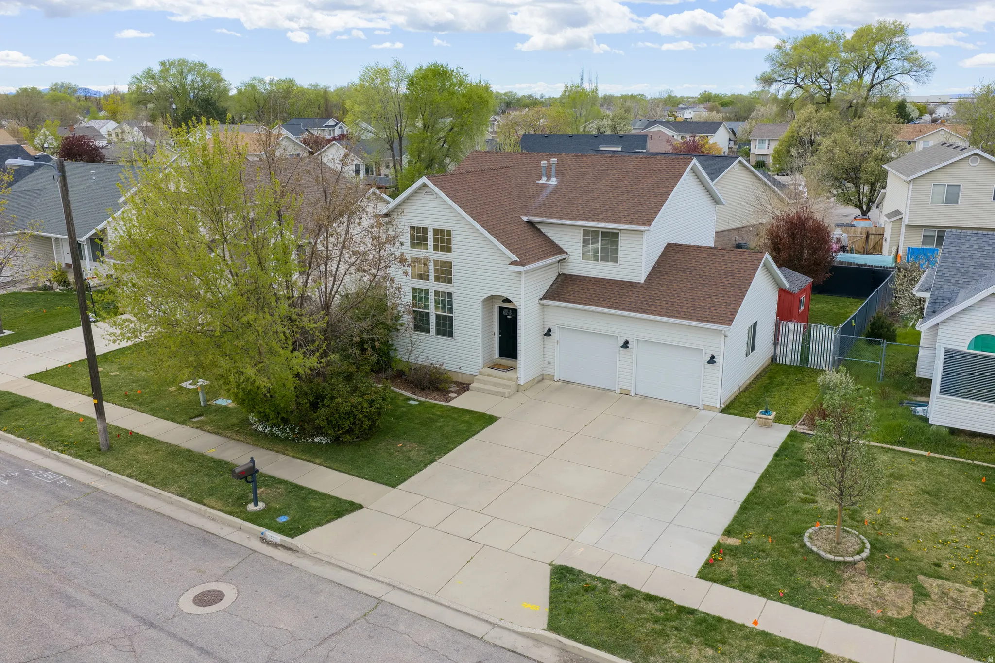 Traditional home featuring roof with shingles, concrete driveway, and a residential view