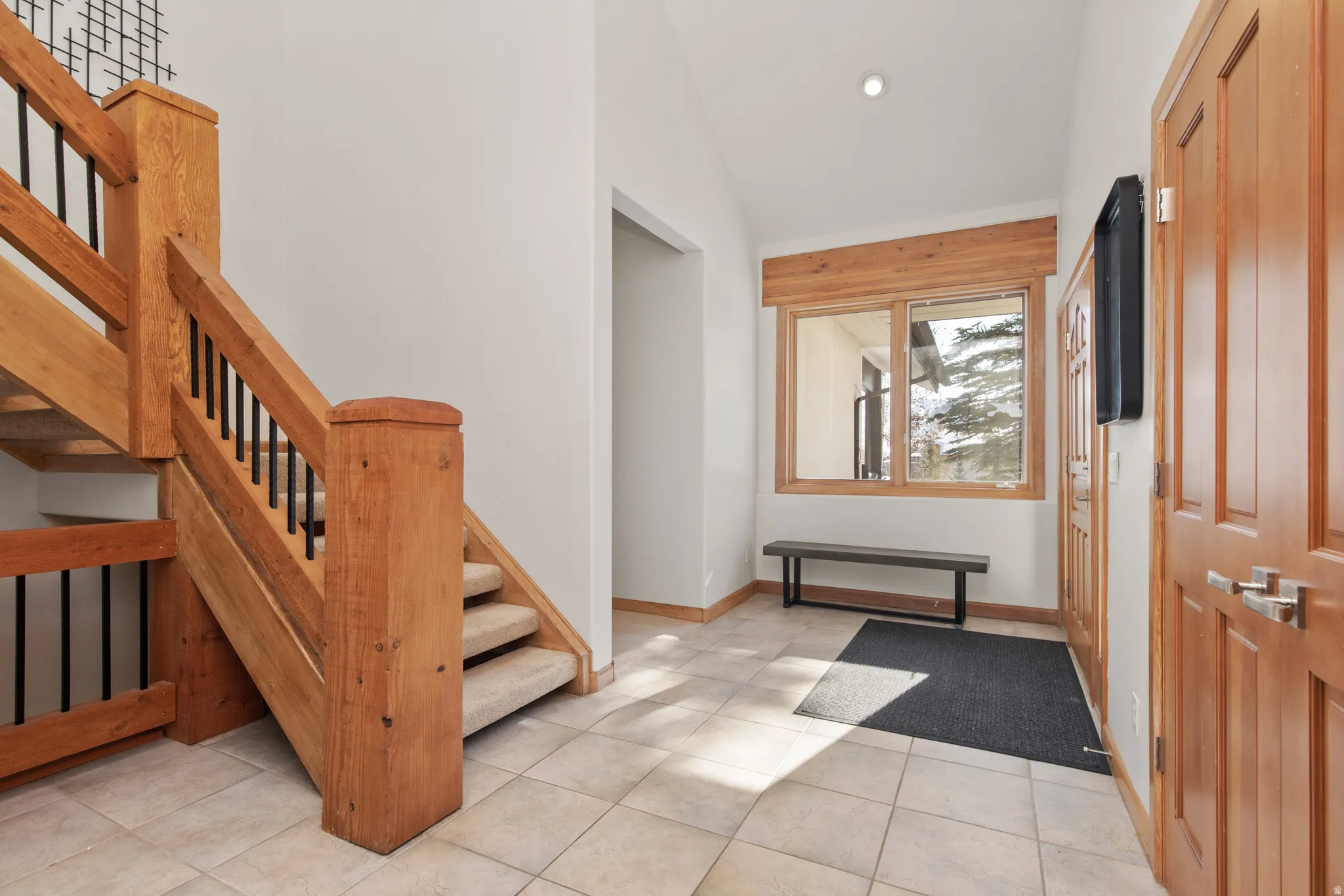 Entryway featuring vaulted ceiling and light tile patterned floors