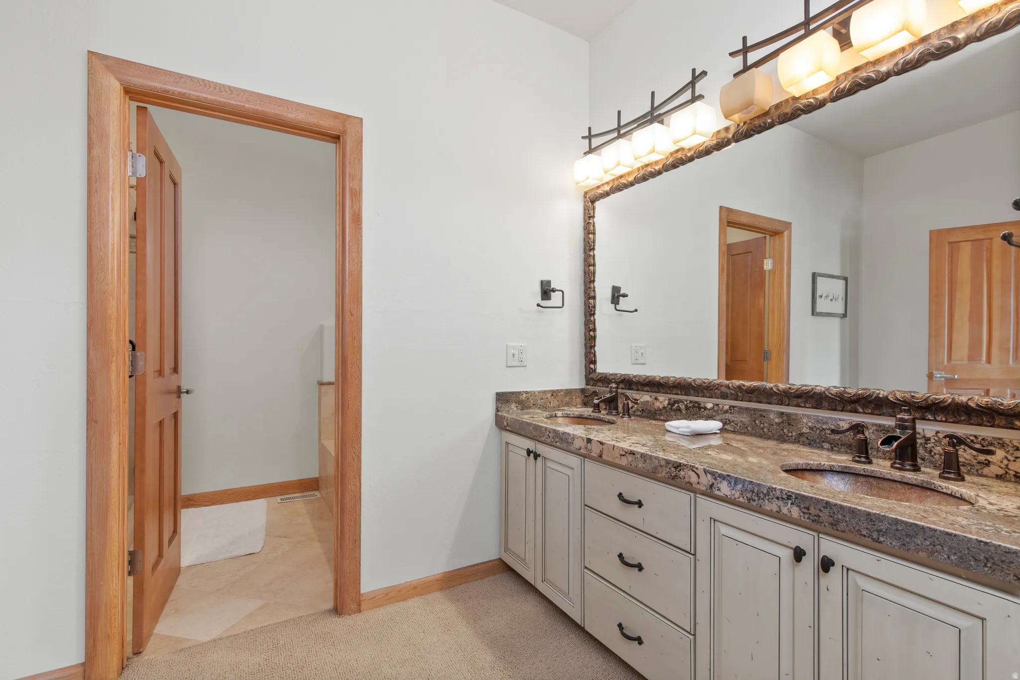 Bathroom featuring double vanity and light colored carpet