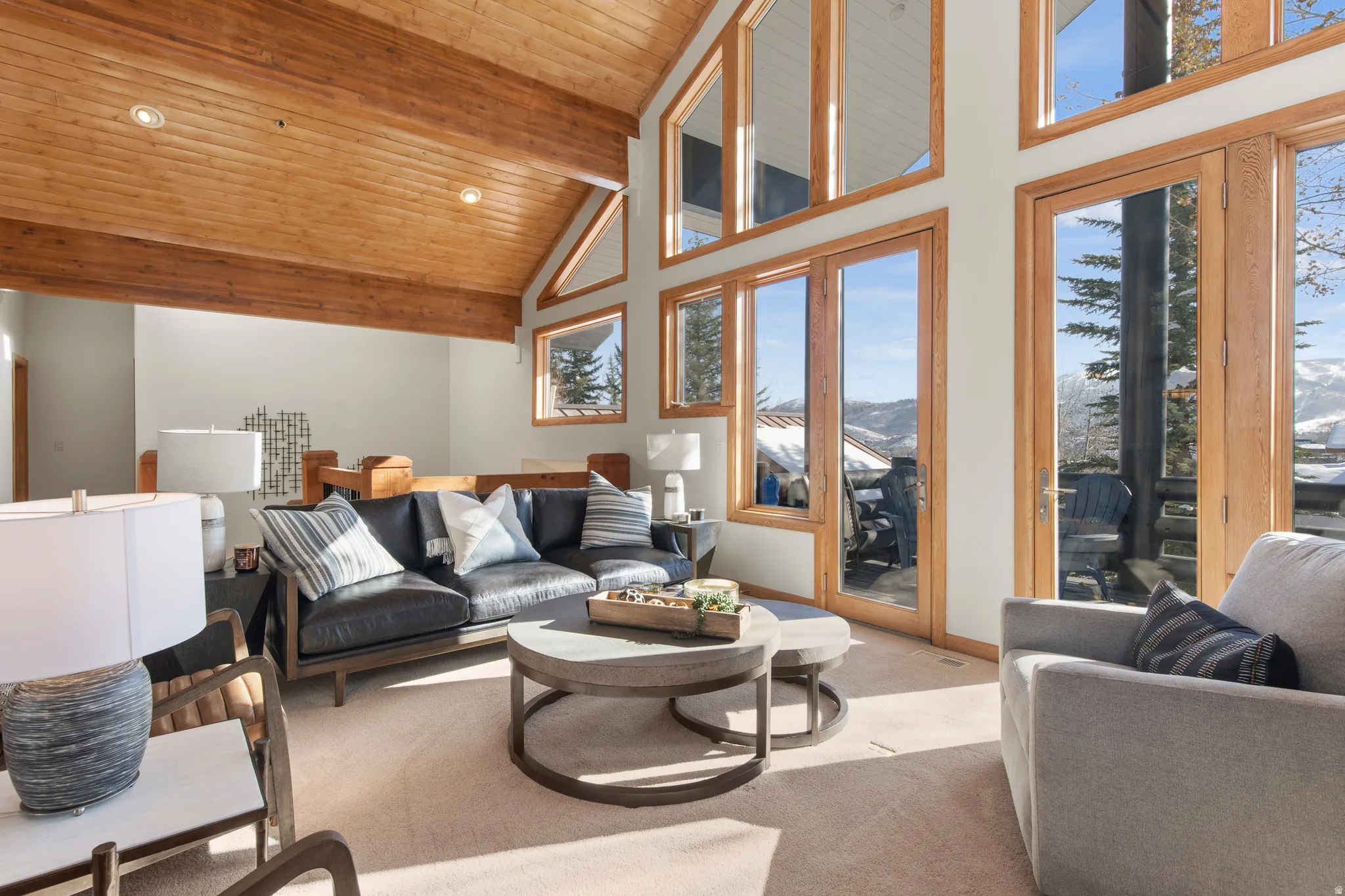 Carpeted living room with a mountain view, recessed lighting, and a high wood beamed ceiling