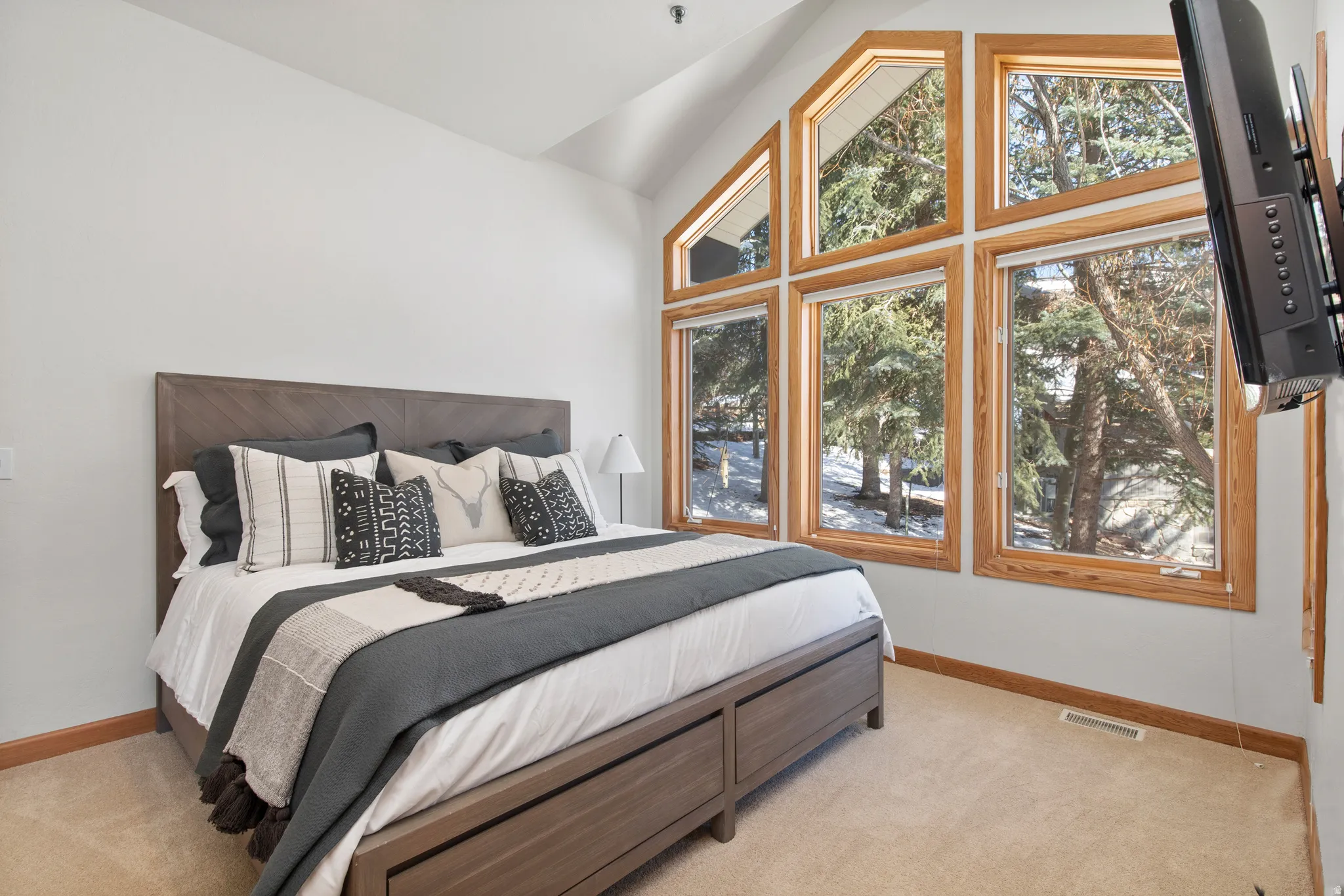 Bedroom with lofted ceiling and light colored carpet
