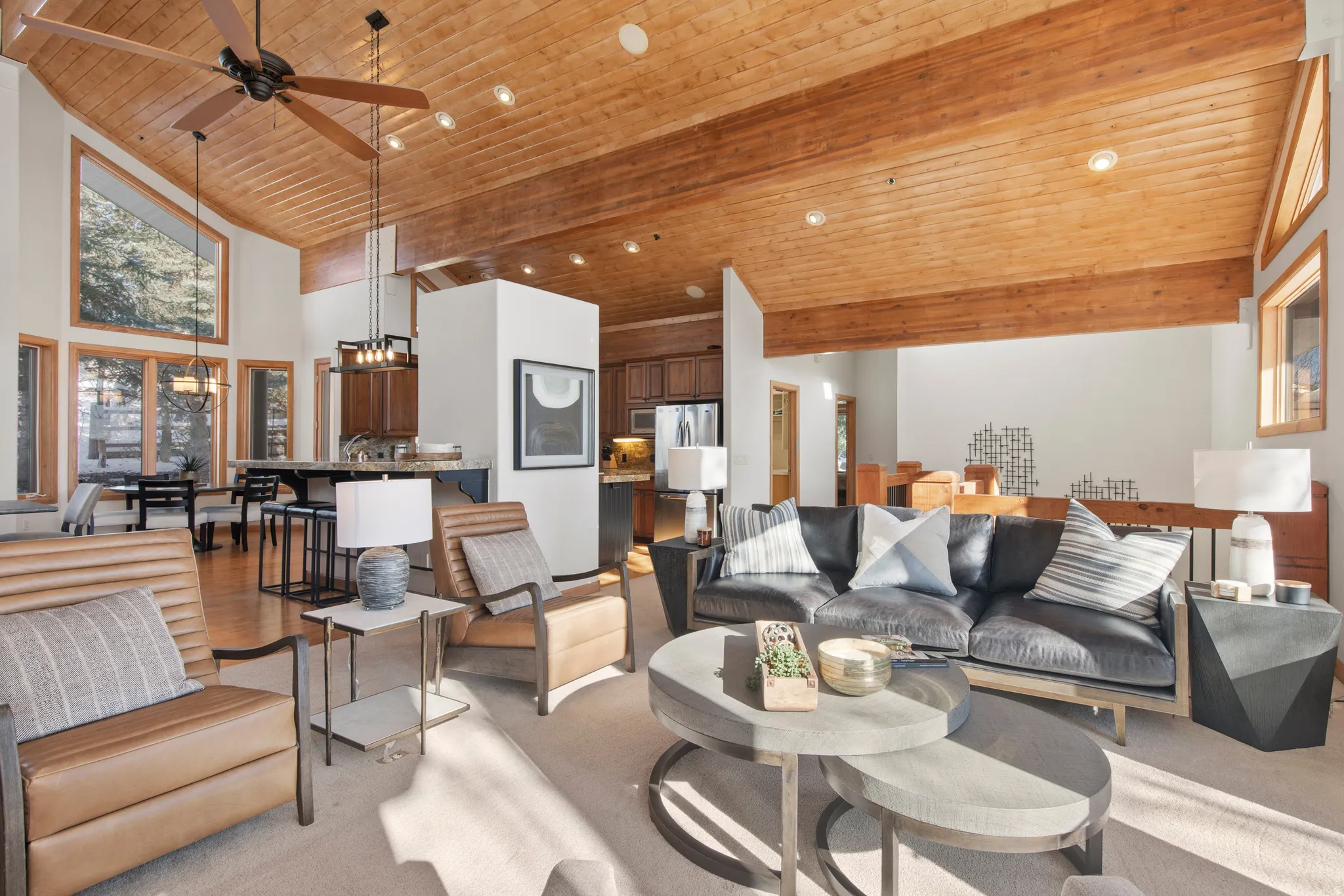 Living area with a ceiling fan, a vaulted wood ceiling, and a chandelier
