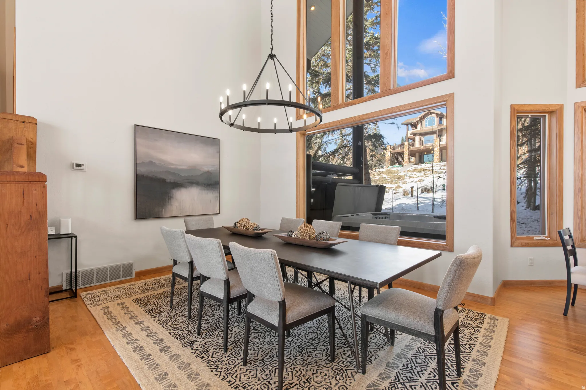 Dining area featuring a high ceiling, suspended lighting, and light wood finished floors