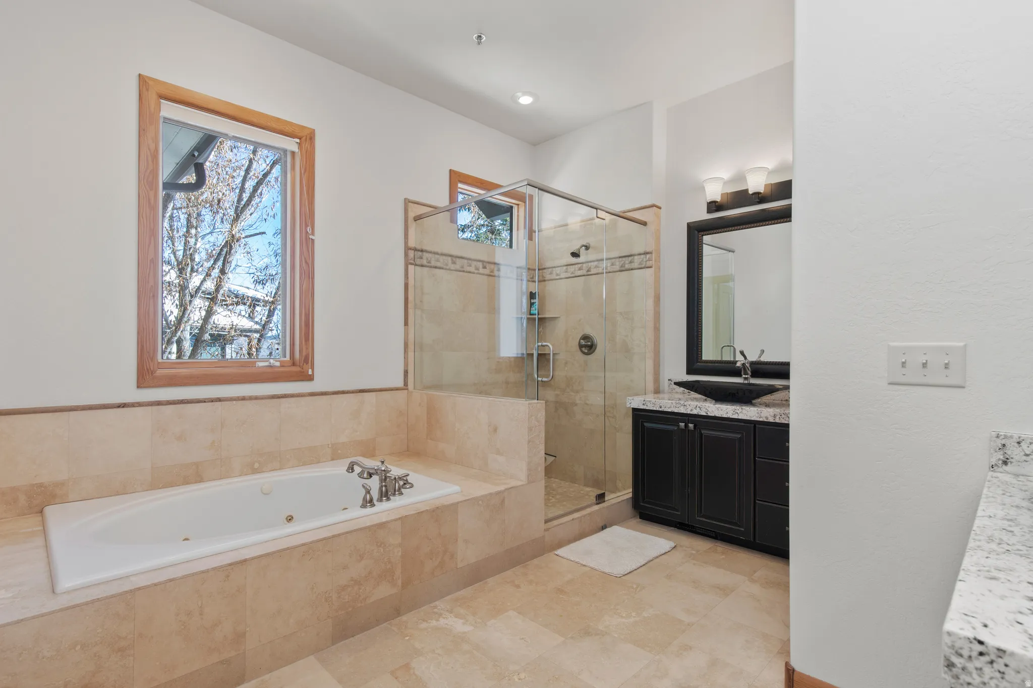 Full bath with vanity, a stall shower, and a whirlpool tub