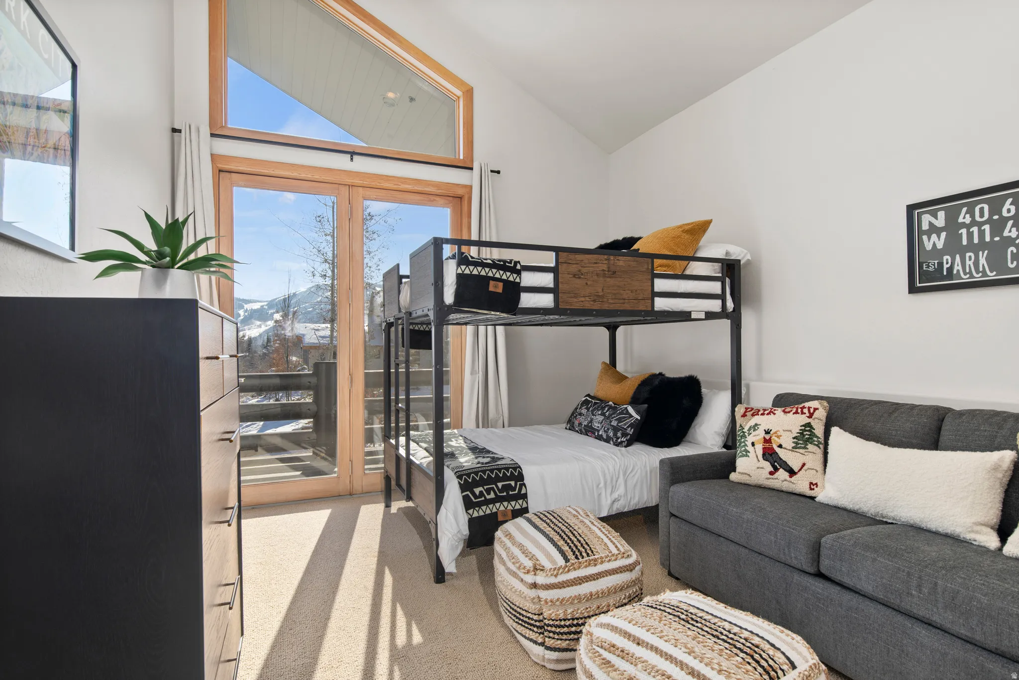 Bedroom with access to exterior, light colored carpet, and lofted ceiling