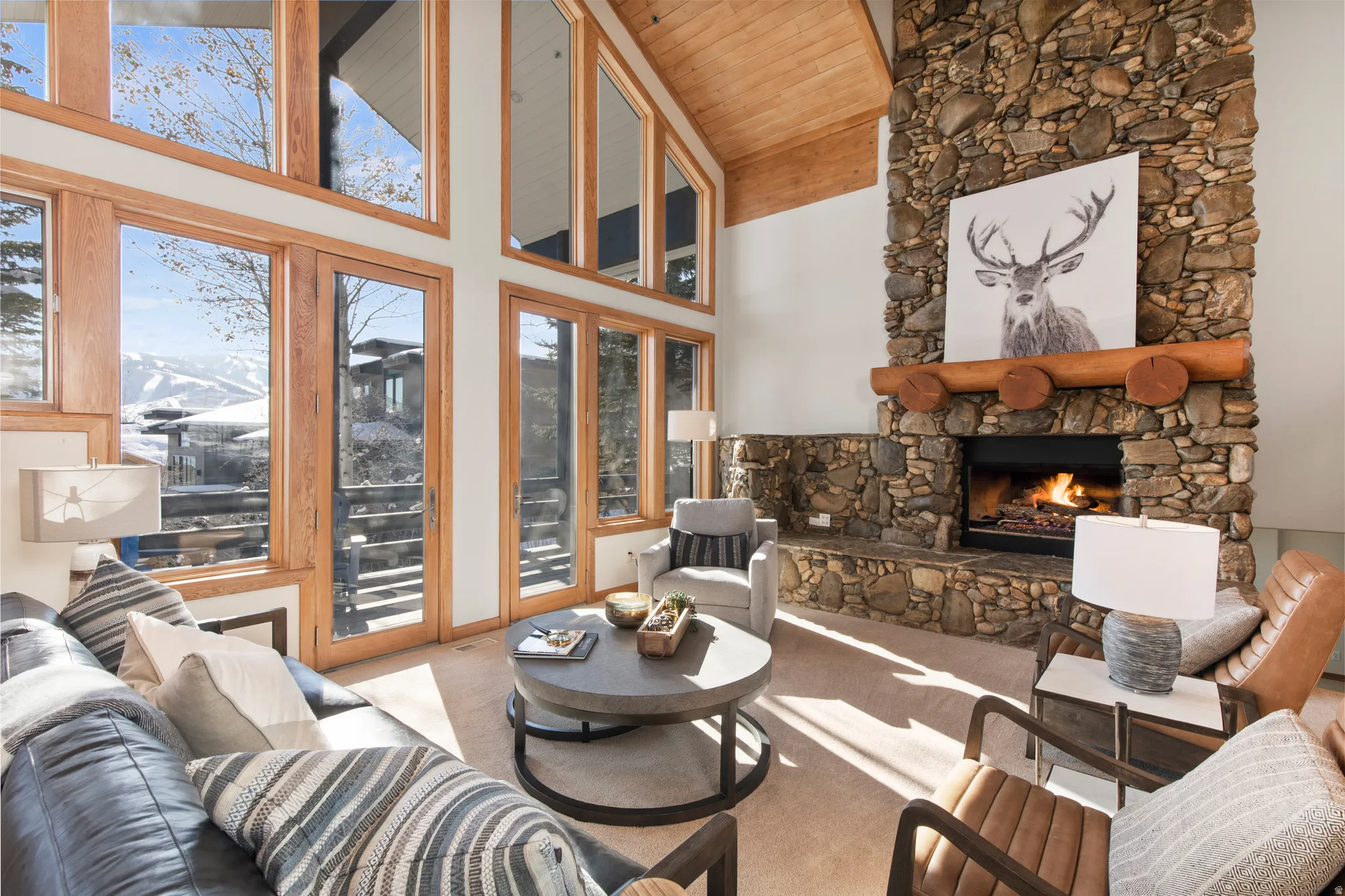 Living area with a fireplace, light carpet, and a vaulted wooden ceiling