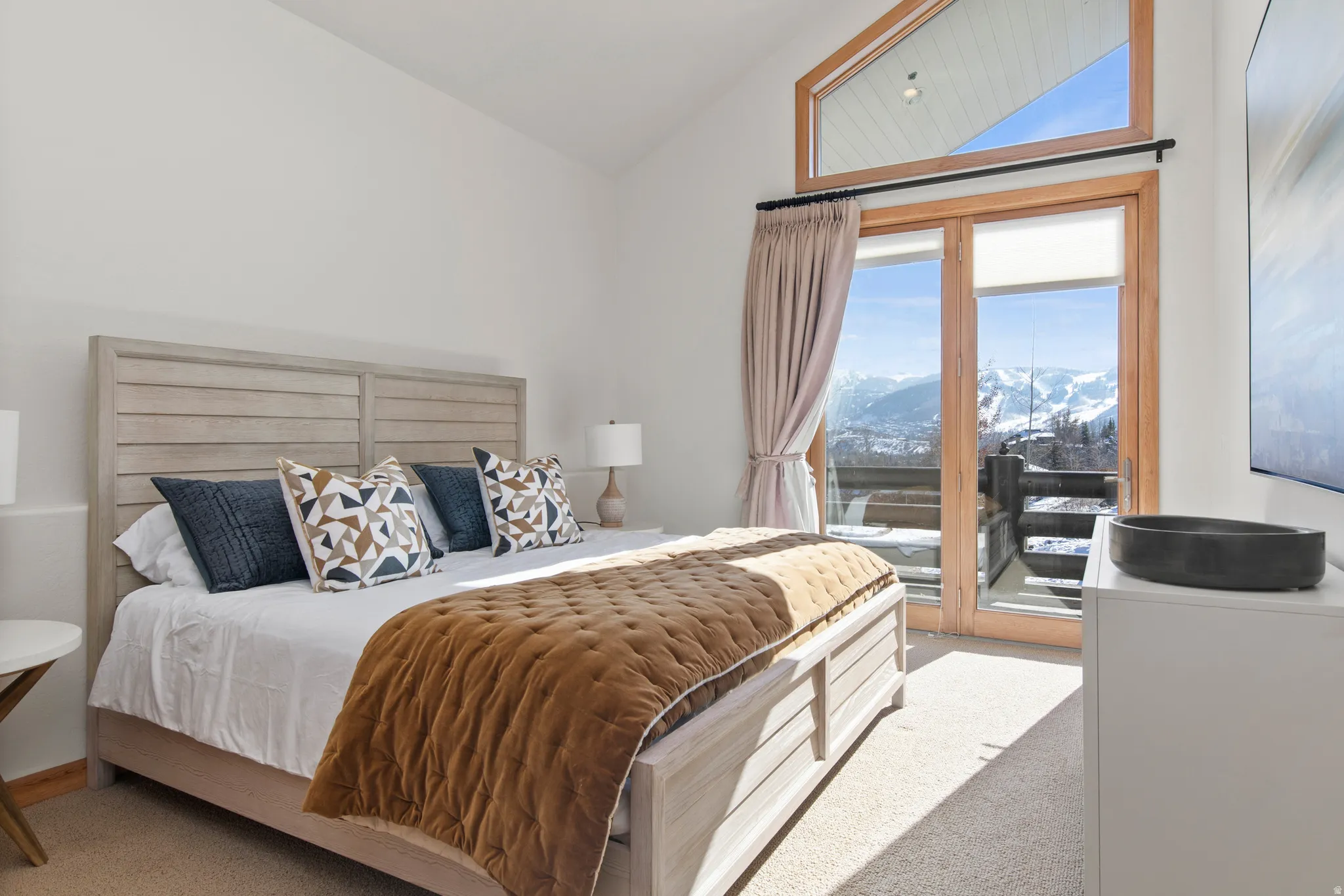 Bedroom featuring vaulted ceiling, light carpet, and access to outside