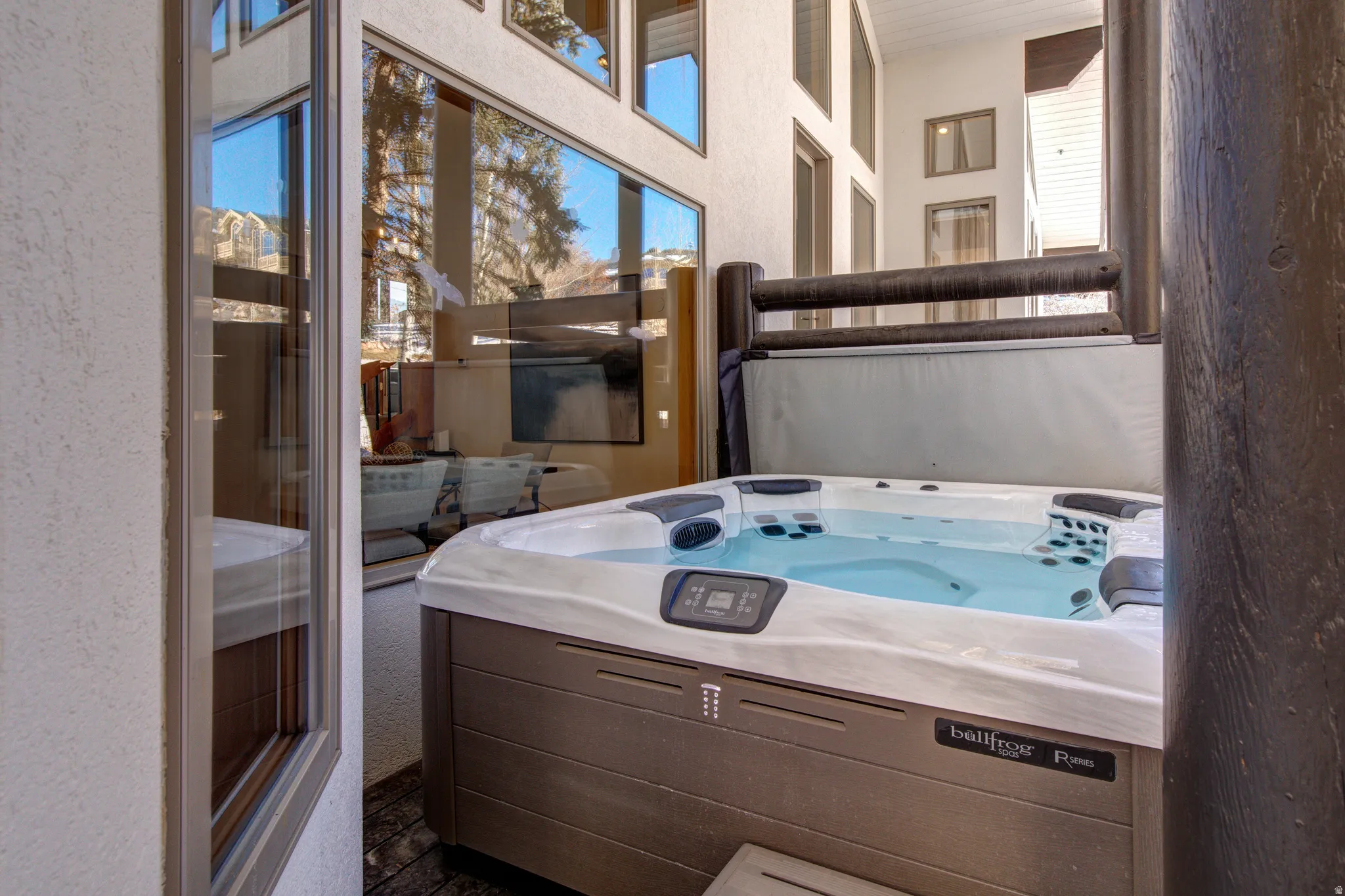 Full bath featuring a textured wall, a high ceiling, and healthy amount of natural light