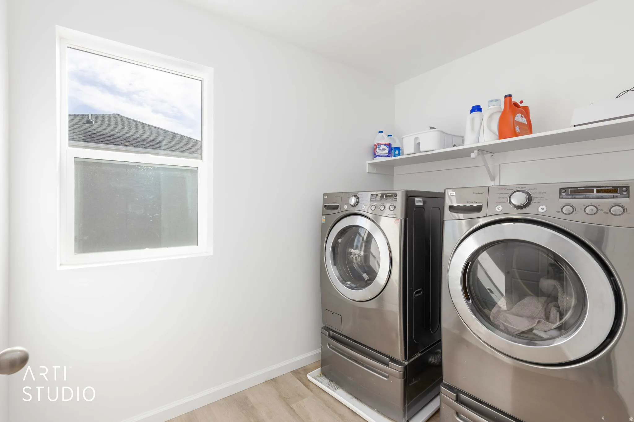 Laundry area featuring light wood-style floors and washing machine and dryer