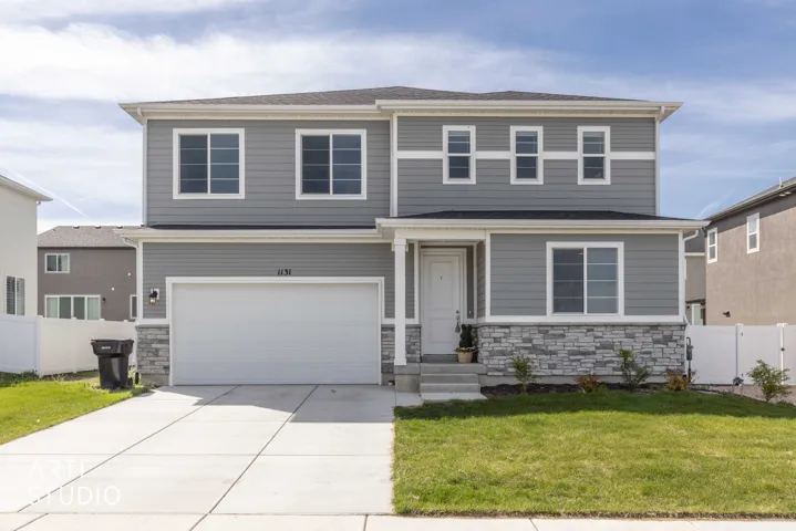 View of front of house with stone siding, an attached garage, concrete driveway, and a shingled roof