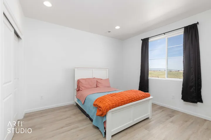 Bedroom with light wood-type flooring, recessed lighting, and a closet