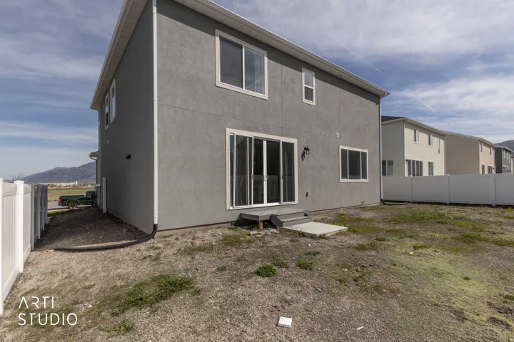 Back of property featuring a fenced backyard and stucco siding