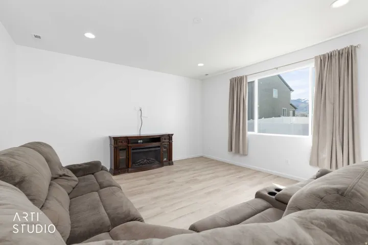Living area featuring light wood finished floors, recessed lighting, and a fireplace