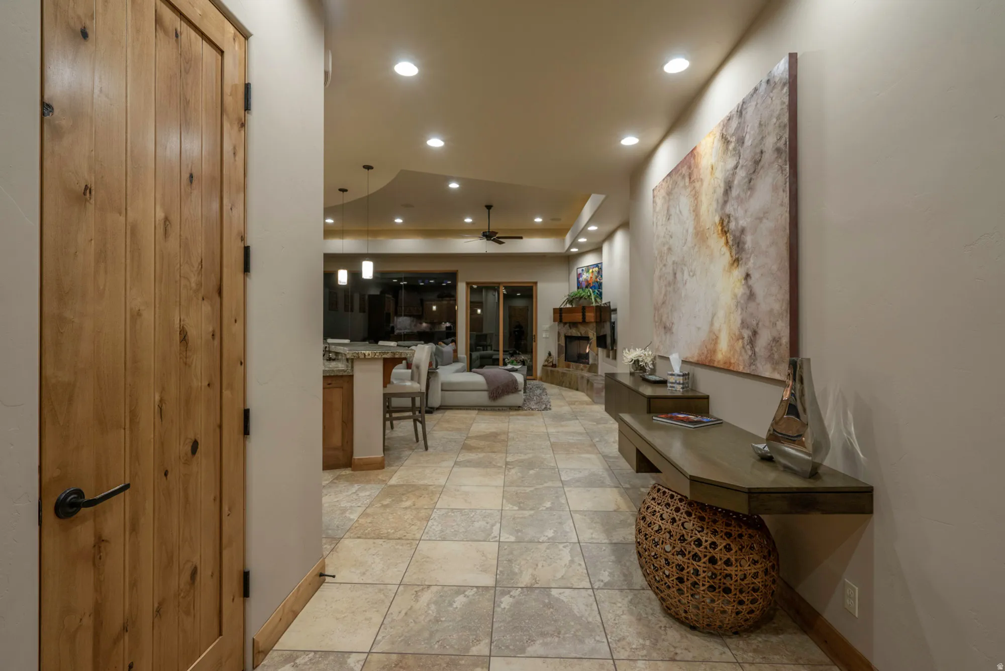 Hall featuring recessed lighting, a tray ceiling, and light stone finish flooring