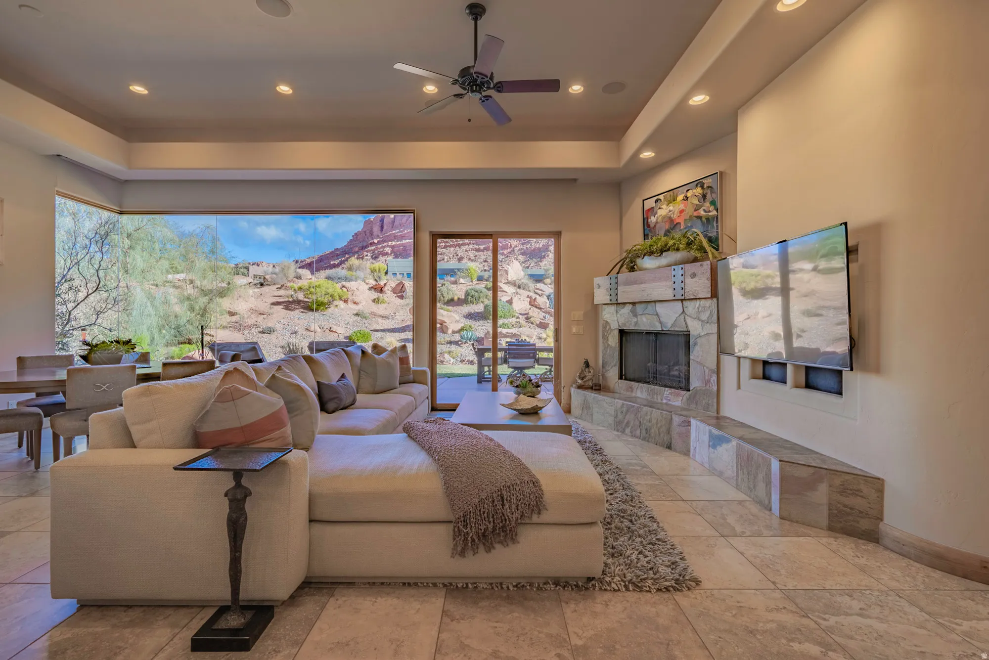 Living room featuring ceiling fan, a fireplace, recessed lighting, and a tray ceiling