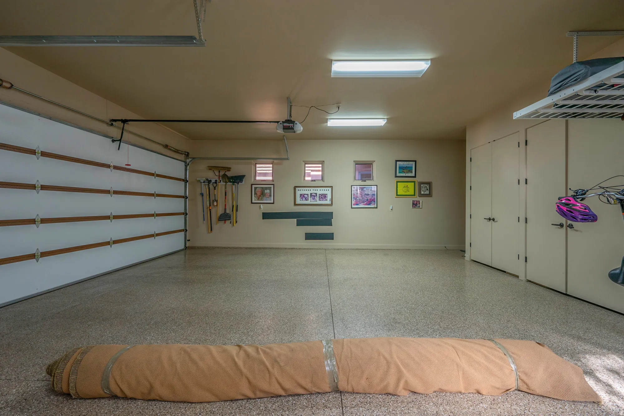 Garage featuring baseboards and a garage door opener