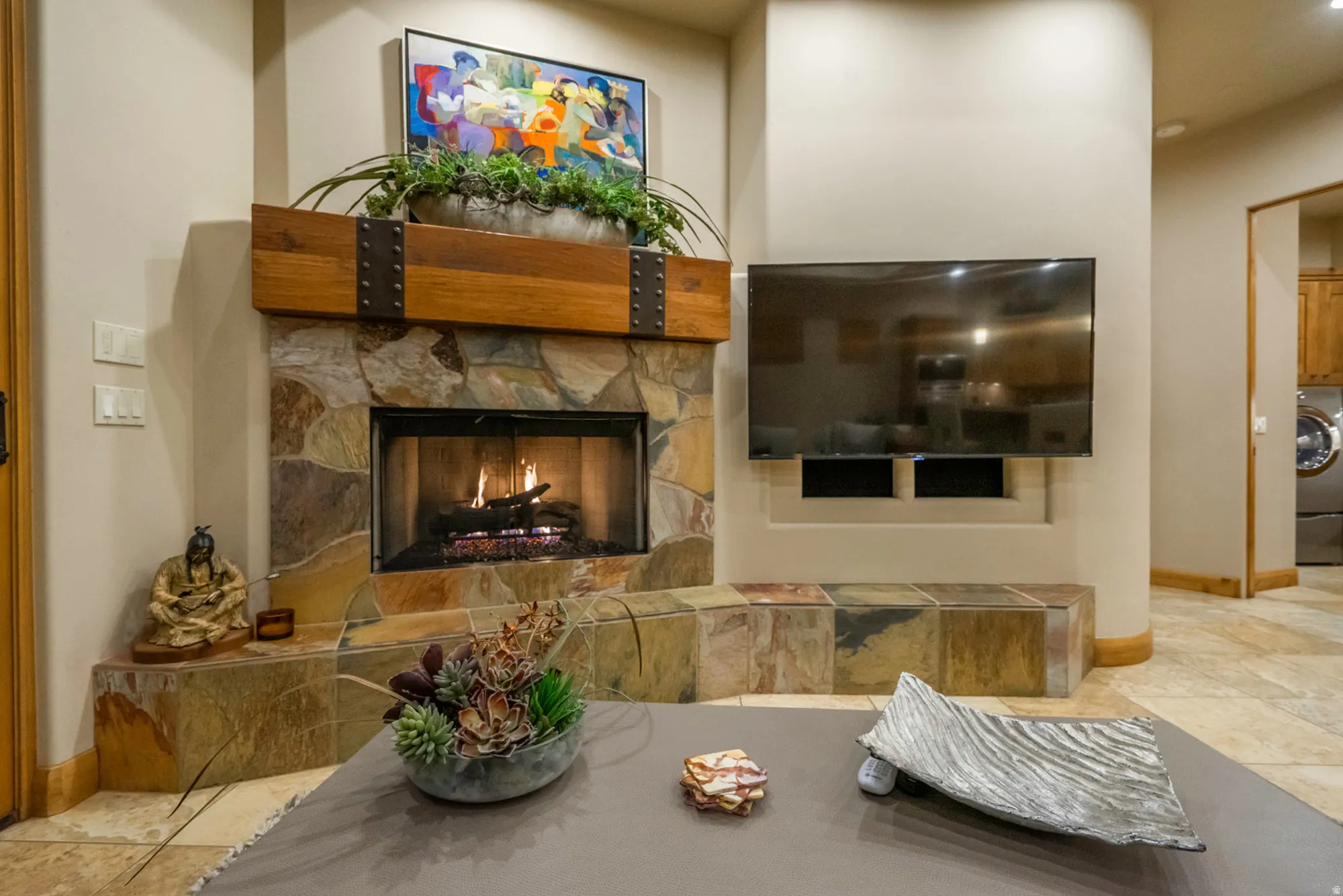 Living room with a fireplace, washer / clothes dryer, and light tile patterned flooring
