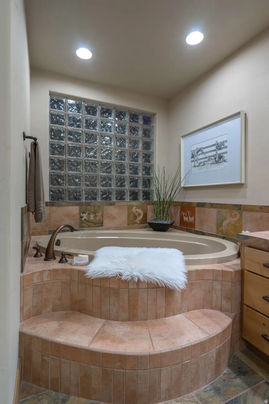 Full bath featuring vanity and a garden tub
