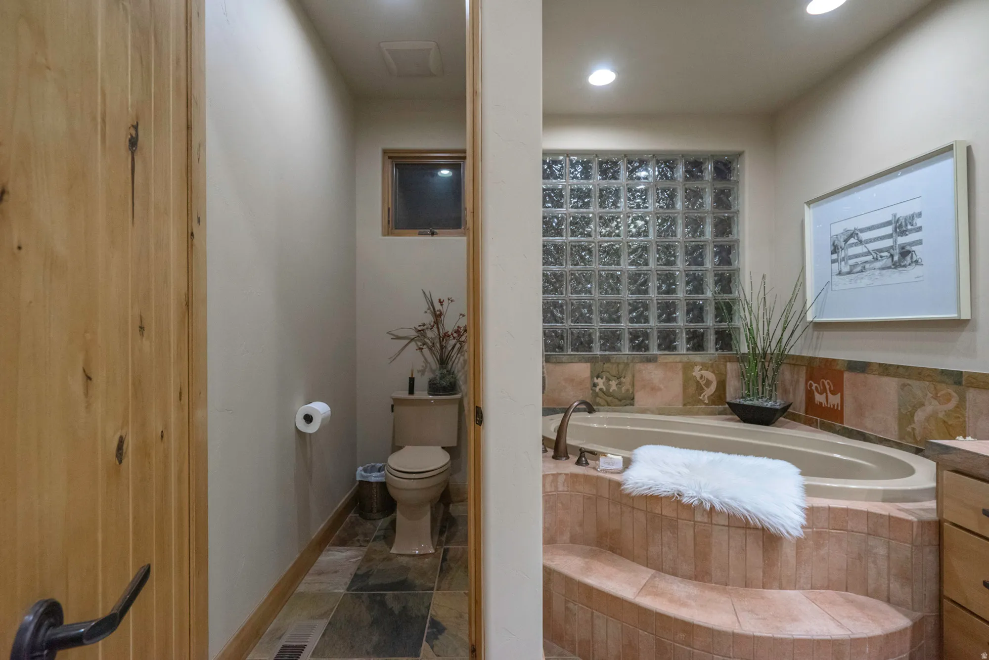 Full bathroom with a bath, vanity, and dark stone finish flooring