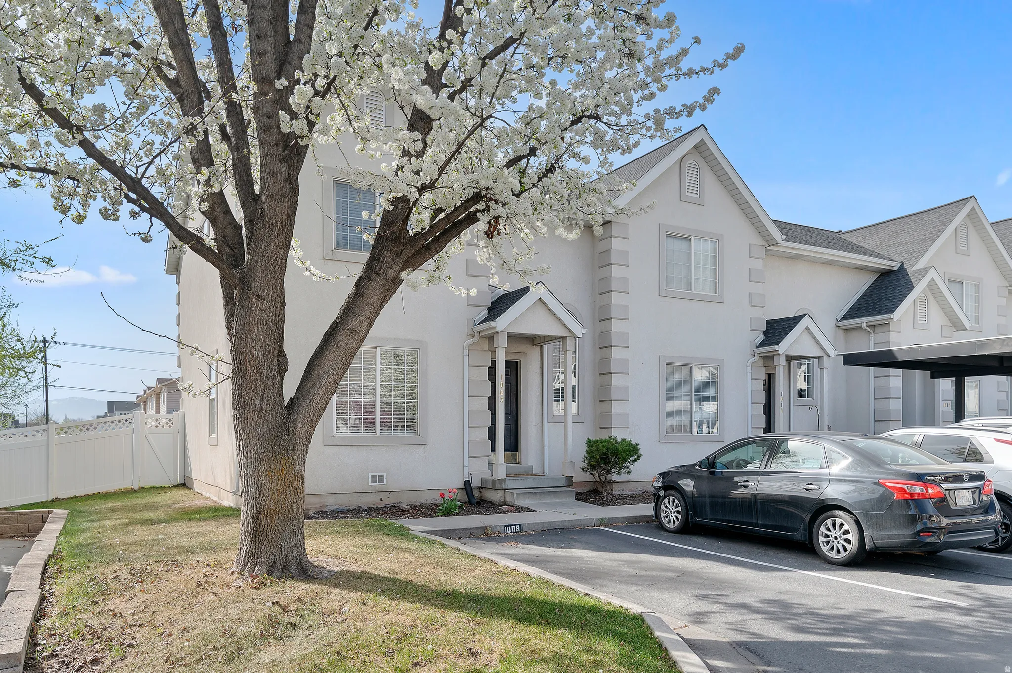 Traditional-style house featuring uncovered parking and stucco siding