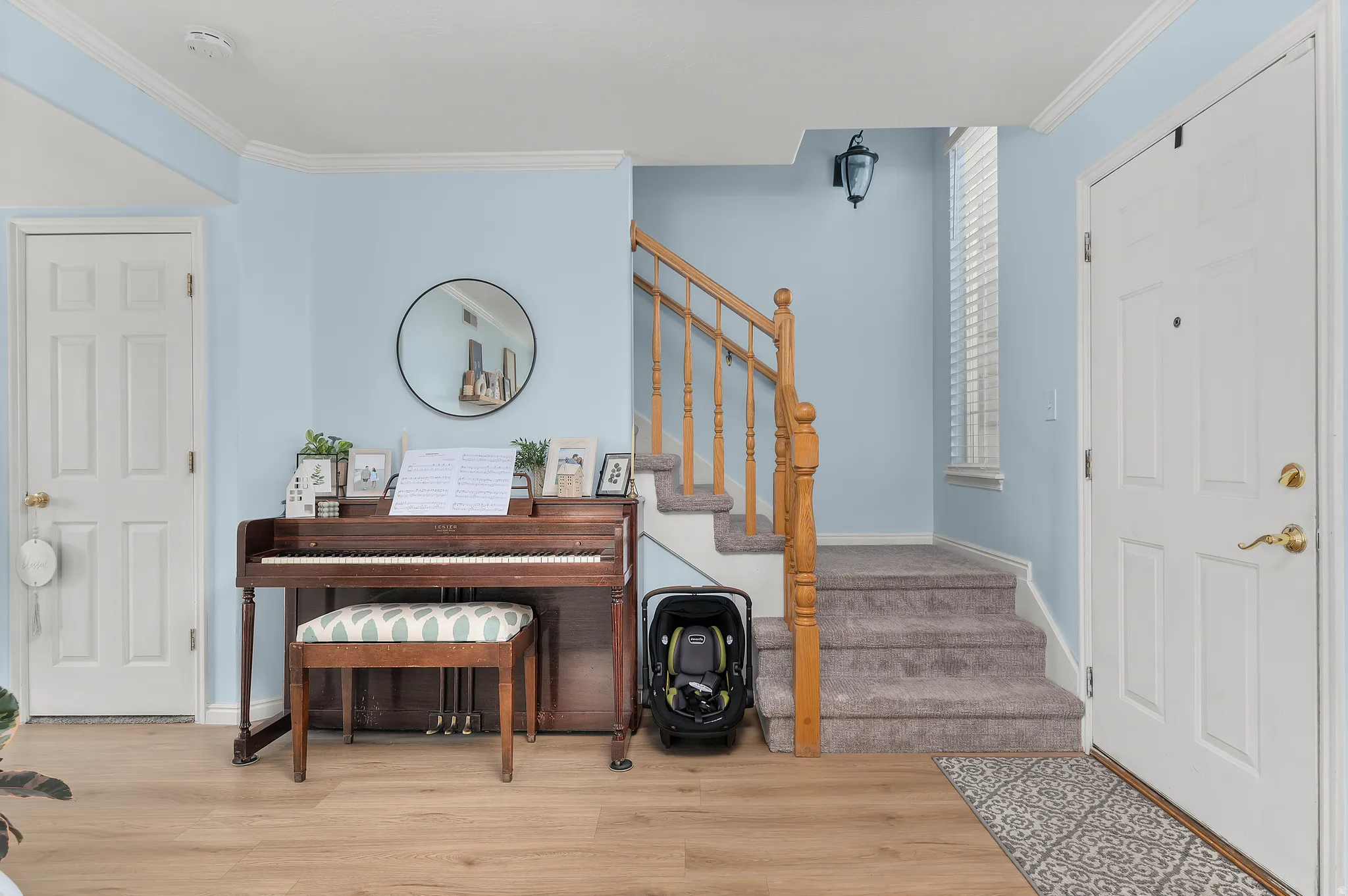 Foyer with crown molding and light wood-style floors