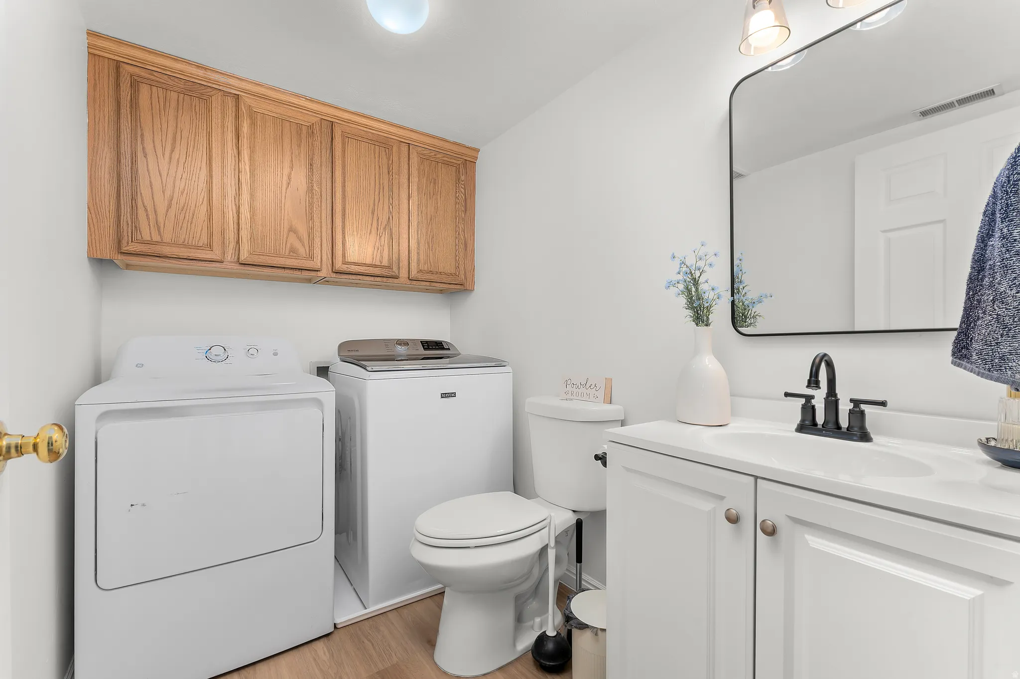 Bathroom featuring vanity, light wood-style flooring, and separate washer and dryer