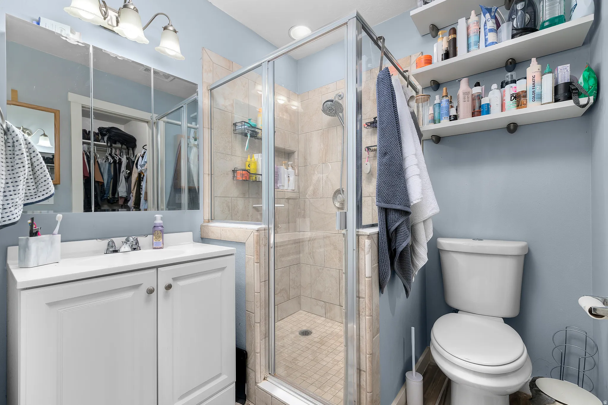 Full bath featuring a shower stall and vanity