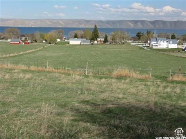 View of mountain backdrop featuring rural landscape and a nearby body of water