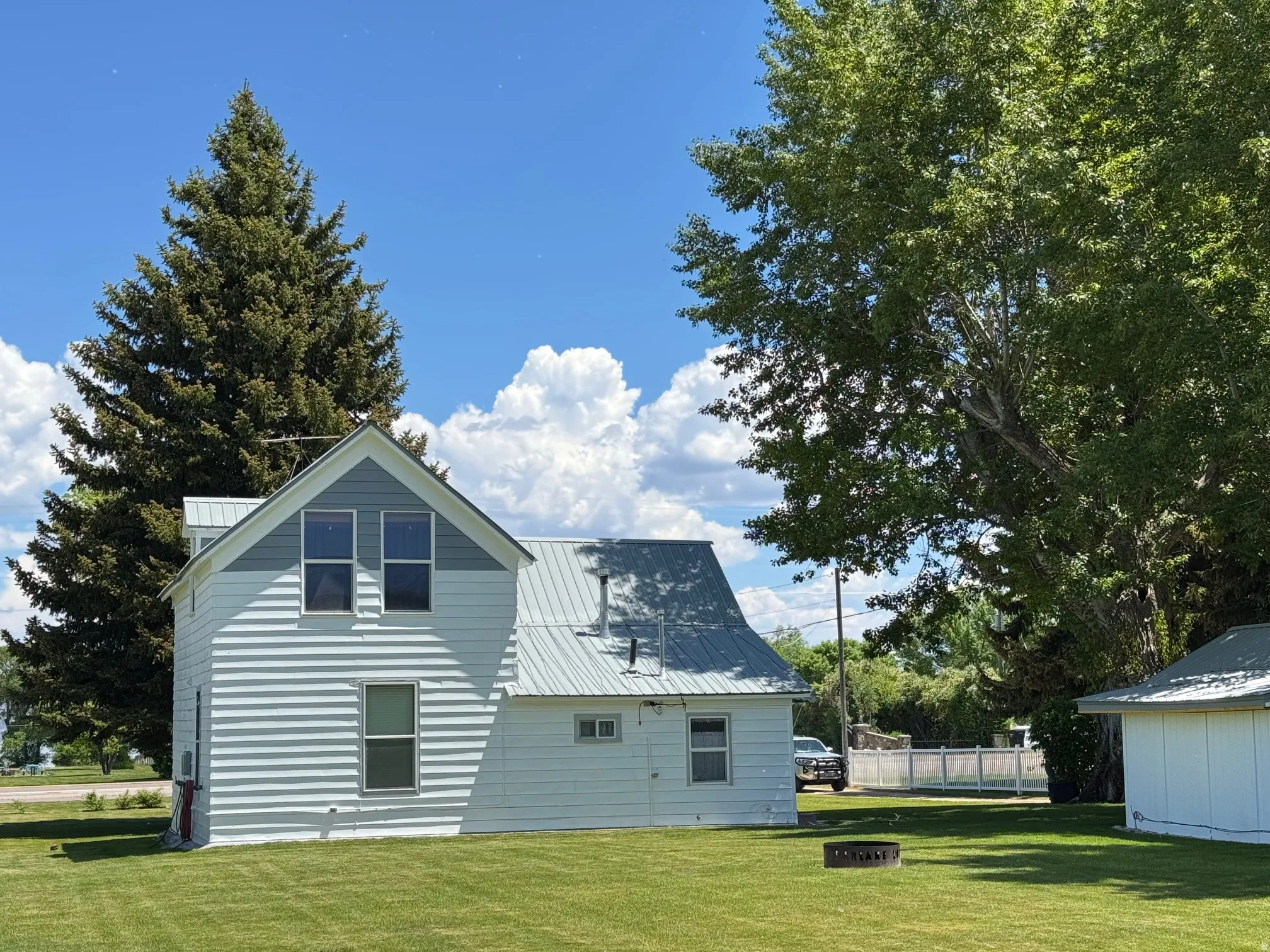 Back of property with an outdoor fire pit and a metal roof