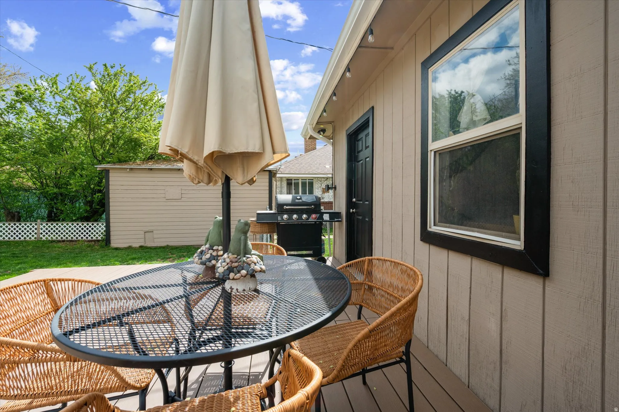 Wooden terrace with outdoor dining space, area for grilling, and a yard