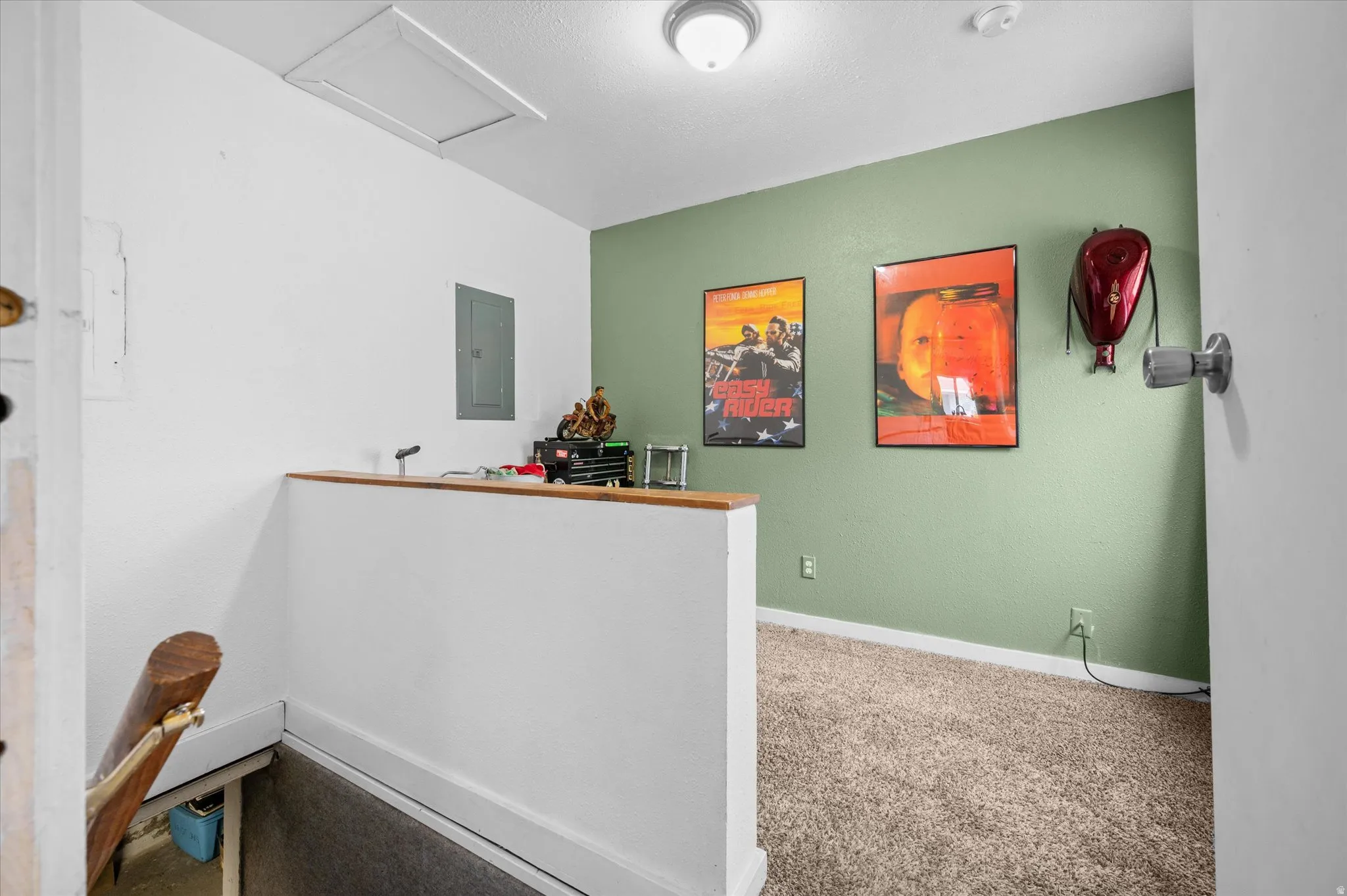 Carpeted home office with attic access and electric panel