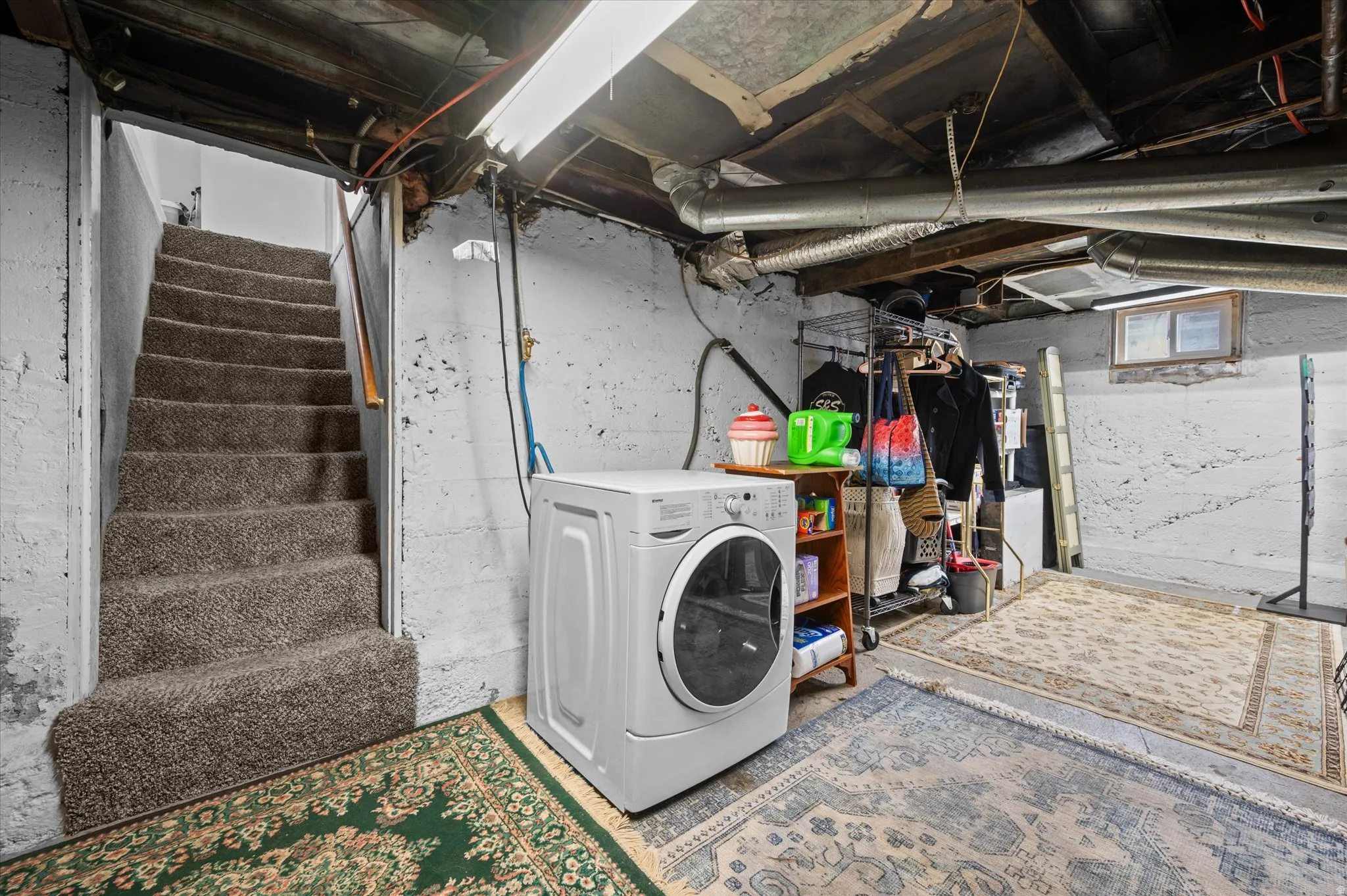 Laundry area featuring washer / clothes dryer and unfinished concrete flooring