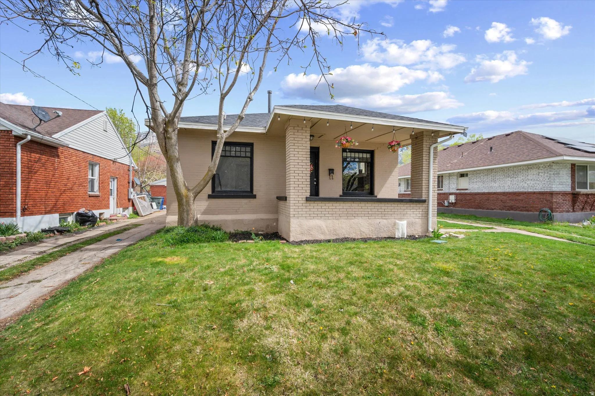 Bungalow-style house with brick siding and a front yard