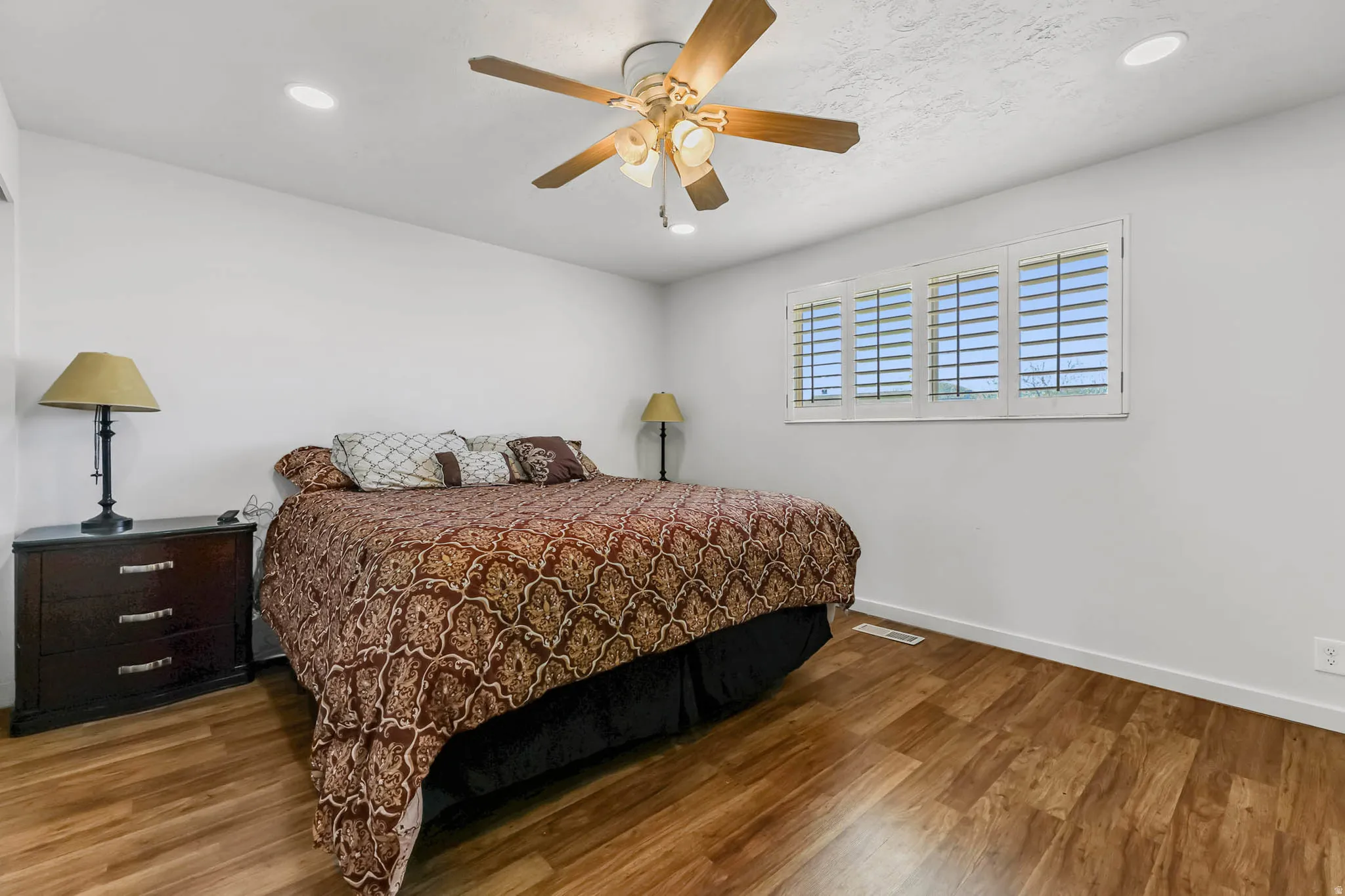 Bedroom with wood finished floors, a ceiling fan, and recessed lighting