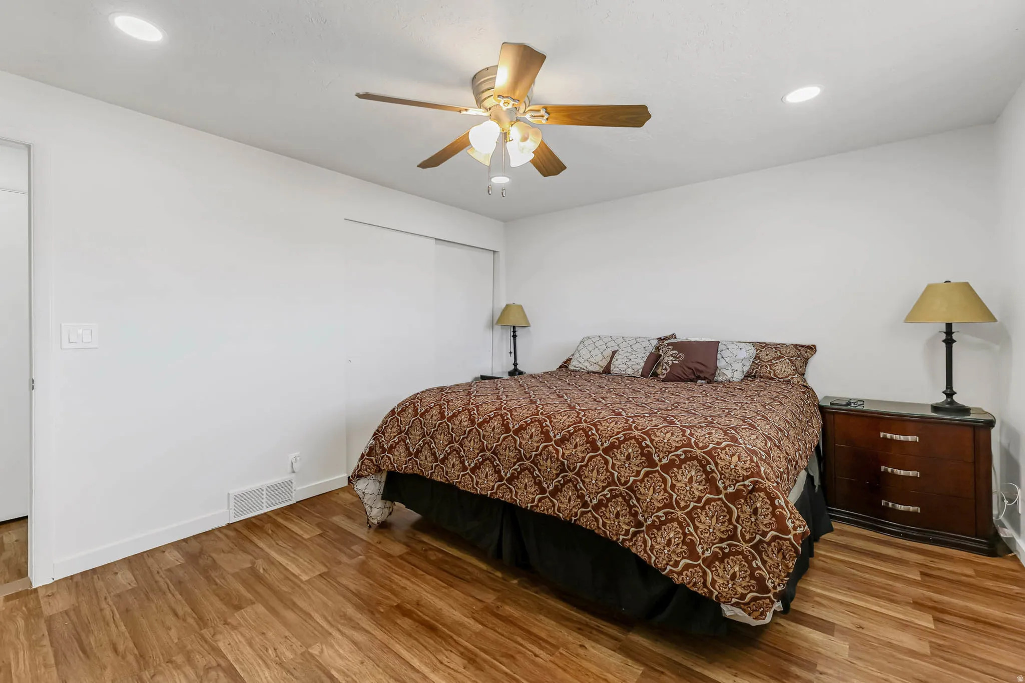 Bedroom featuring light wood-type flooring, a closet, recessed lighting, and a ceiling fan