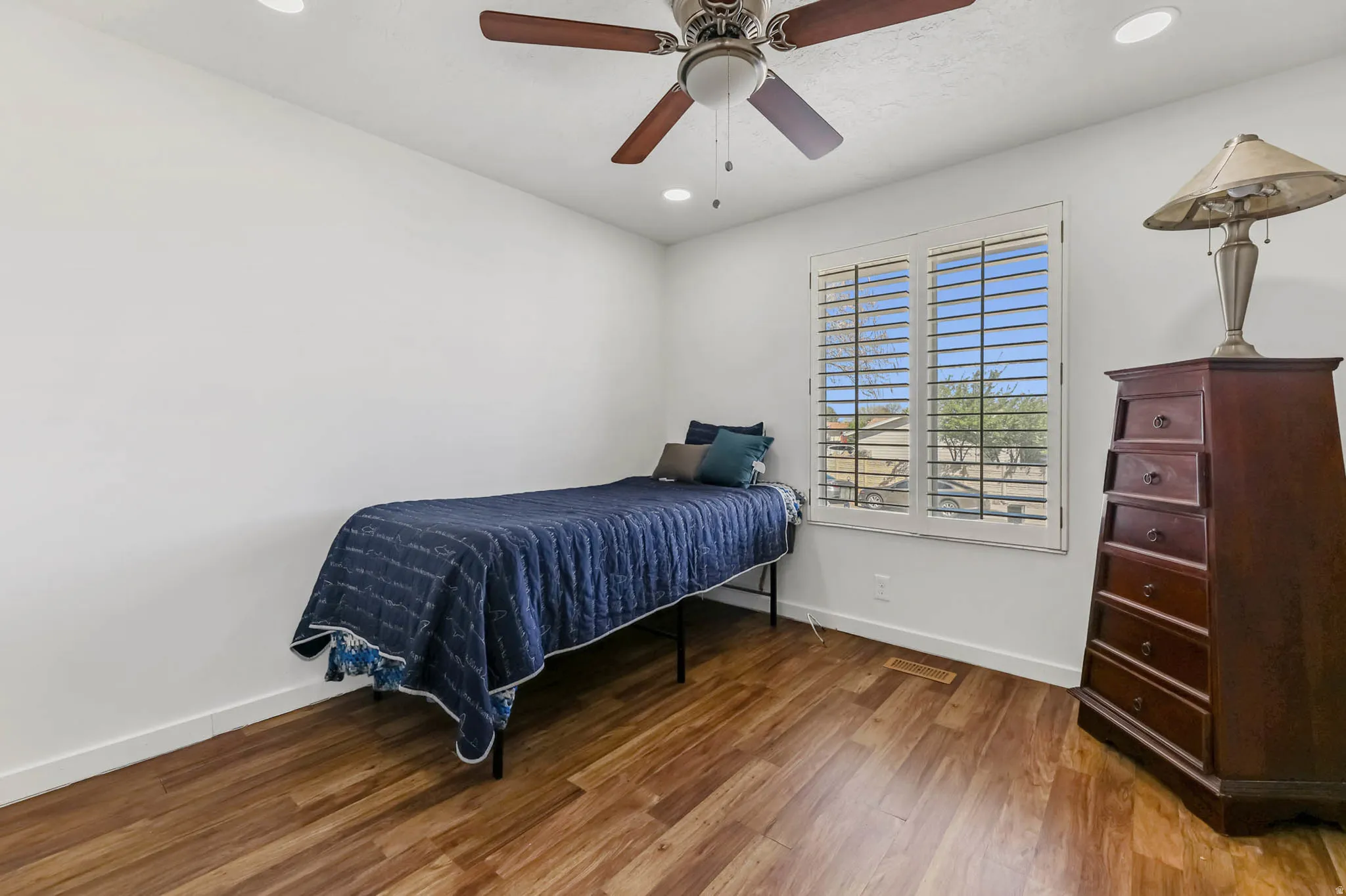 Bedroom with wood finished floors, ceiling fan, and recessed lighting
