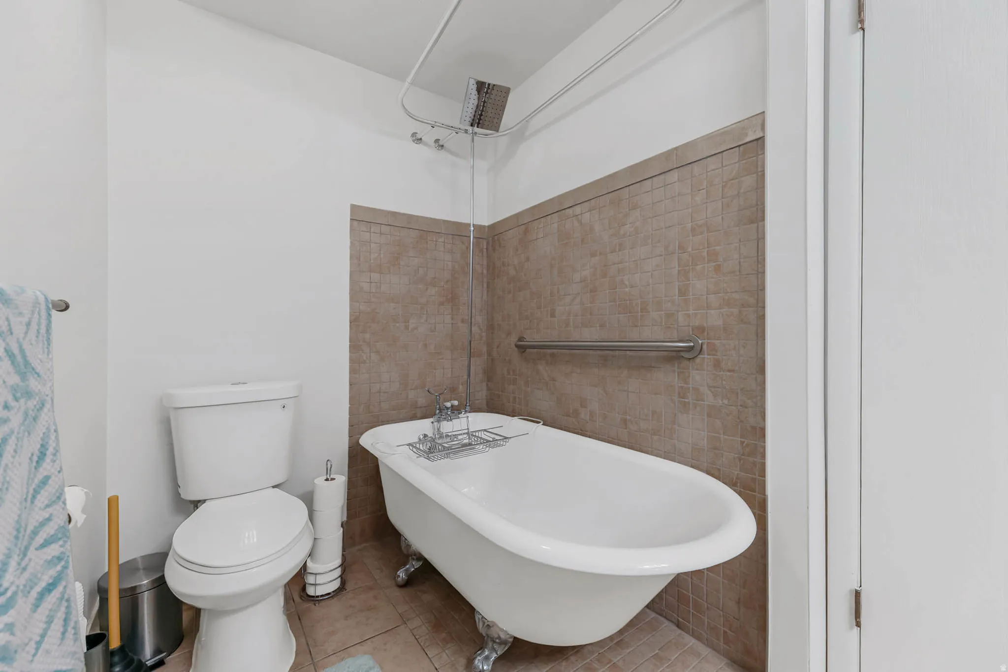 Full bathroom featuring a soaking tub and light tile patterned flooring