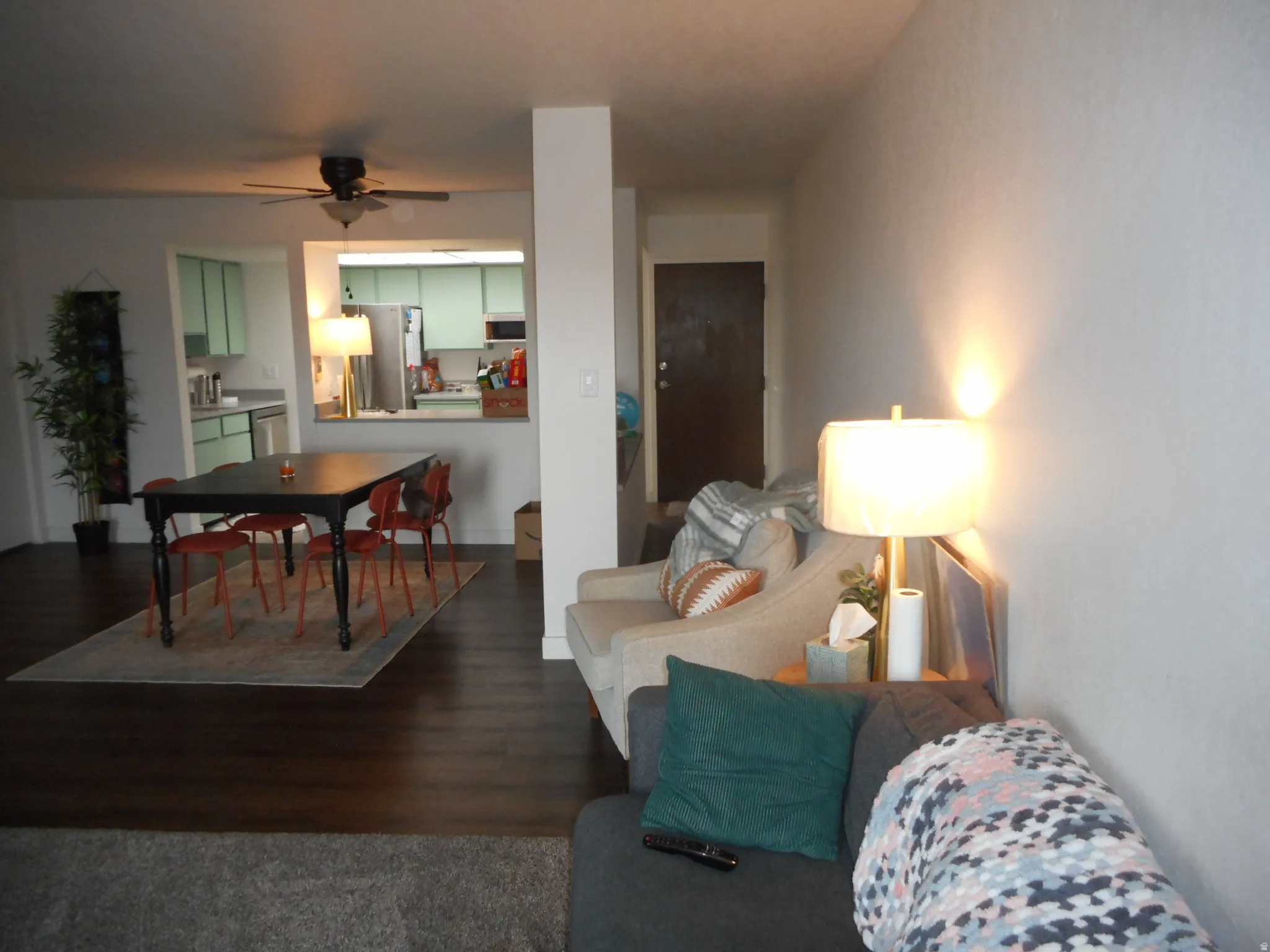 Living area featuring a ceiling fan and dark wood-style floors