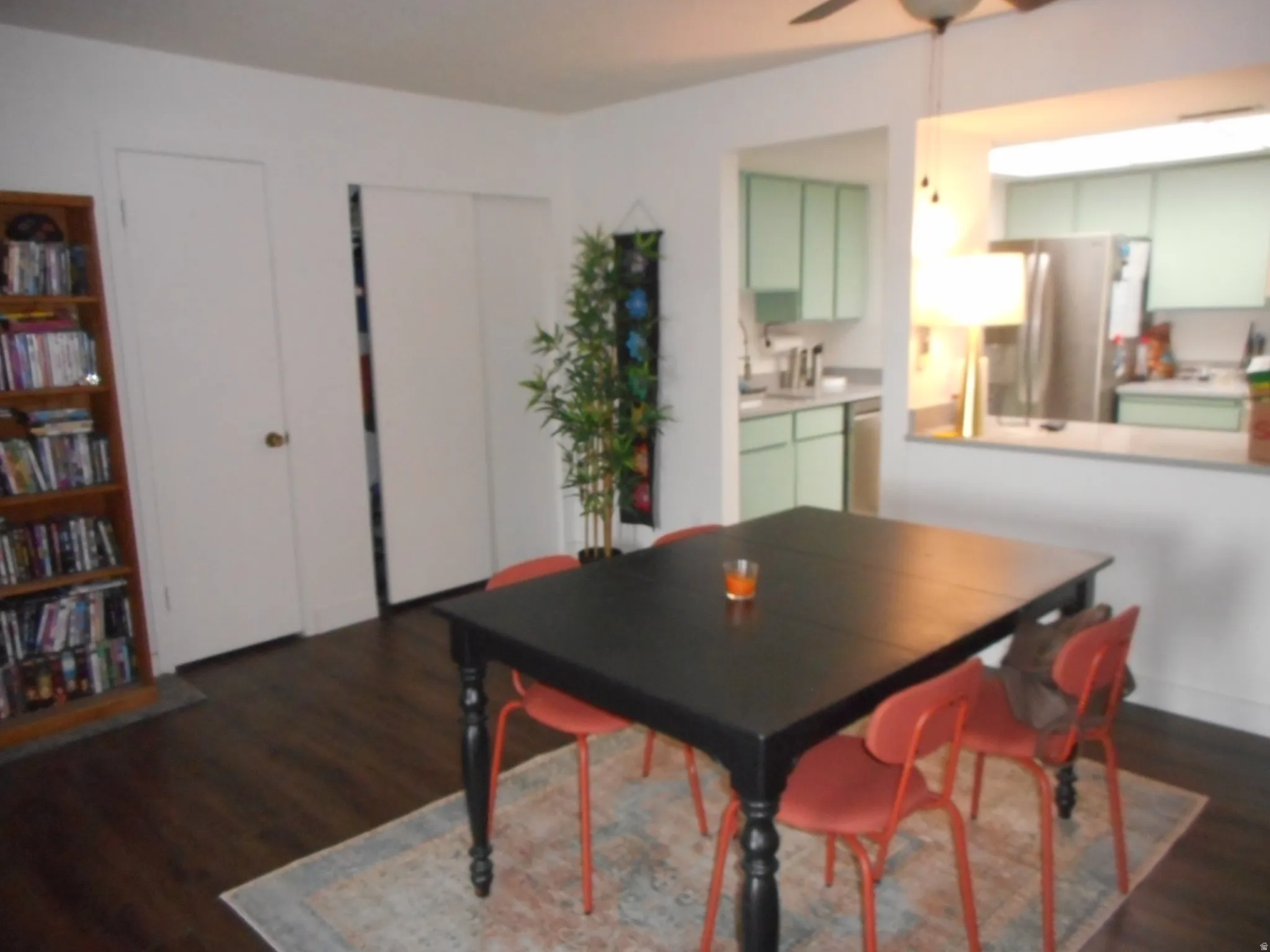 Dining area with dark wood-style flooring and a ceiling fan
