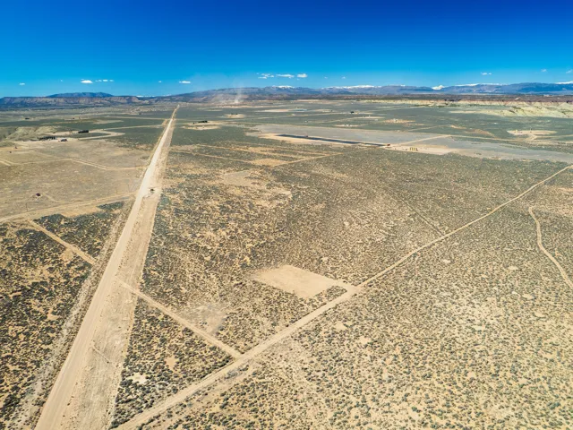 Aerial view of sparsely populated area with a mountainous background and a desert landscape