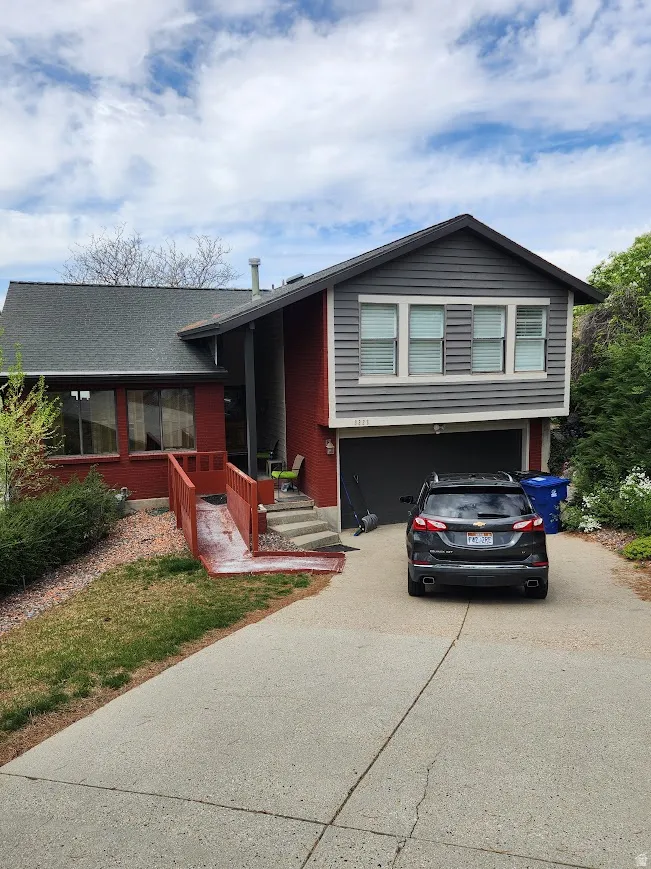 View of front of home with concrete driveway and an attached garage