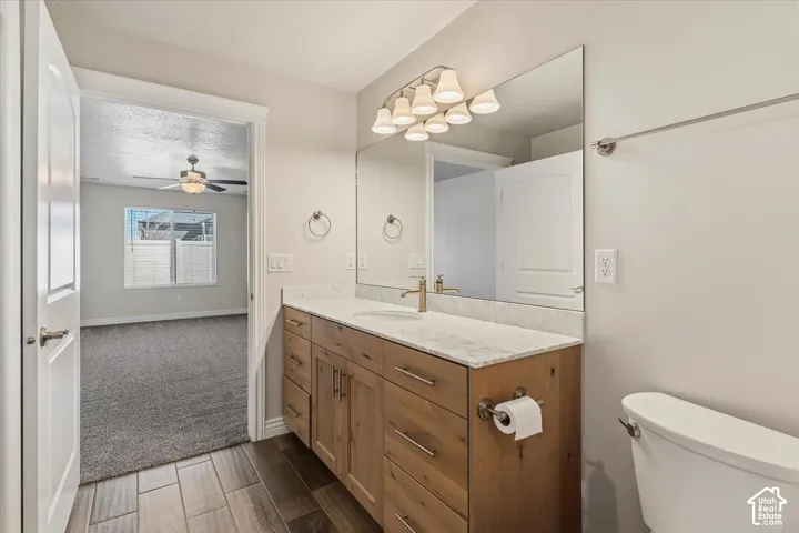 Bathroom featuring vanity, wood tiled floors, and a ceiling fan