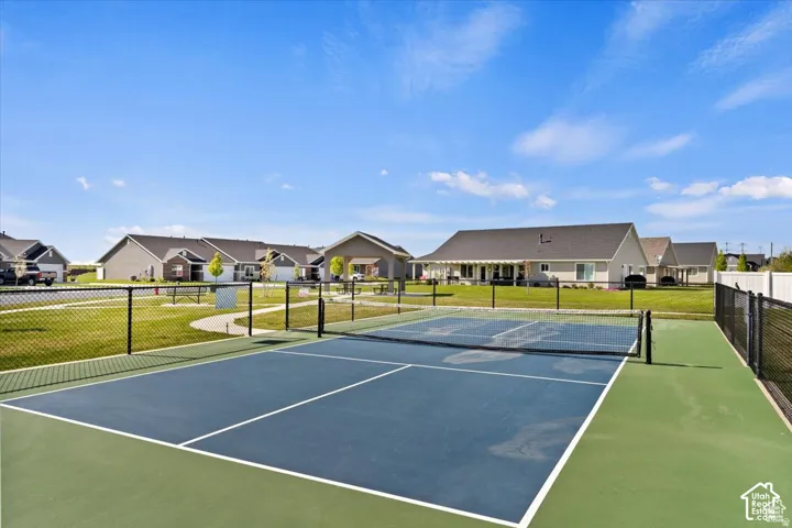Pickleball court with a blue playing surface and green surrounds