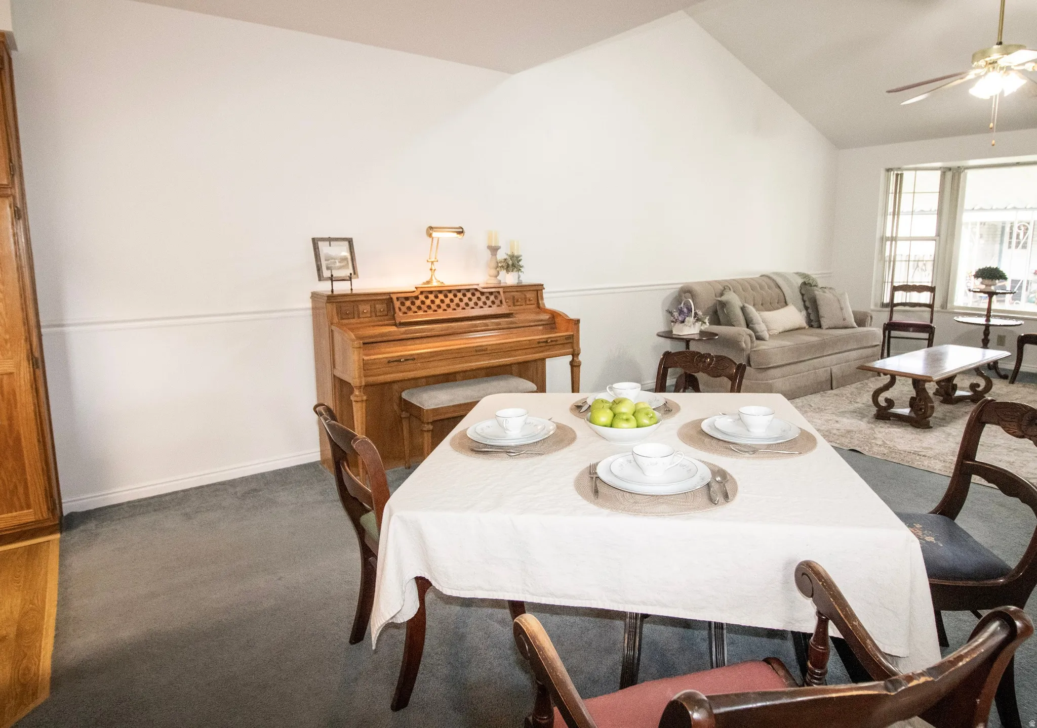 Dining space with dark carpet, a ceiling fan, and lofted ceiling