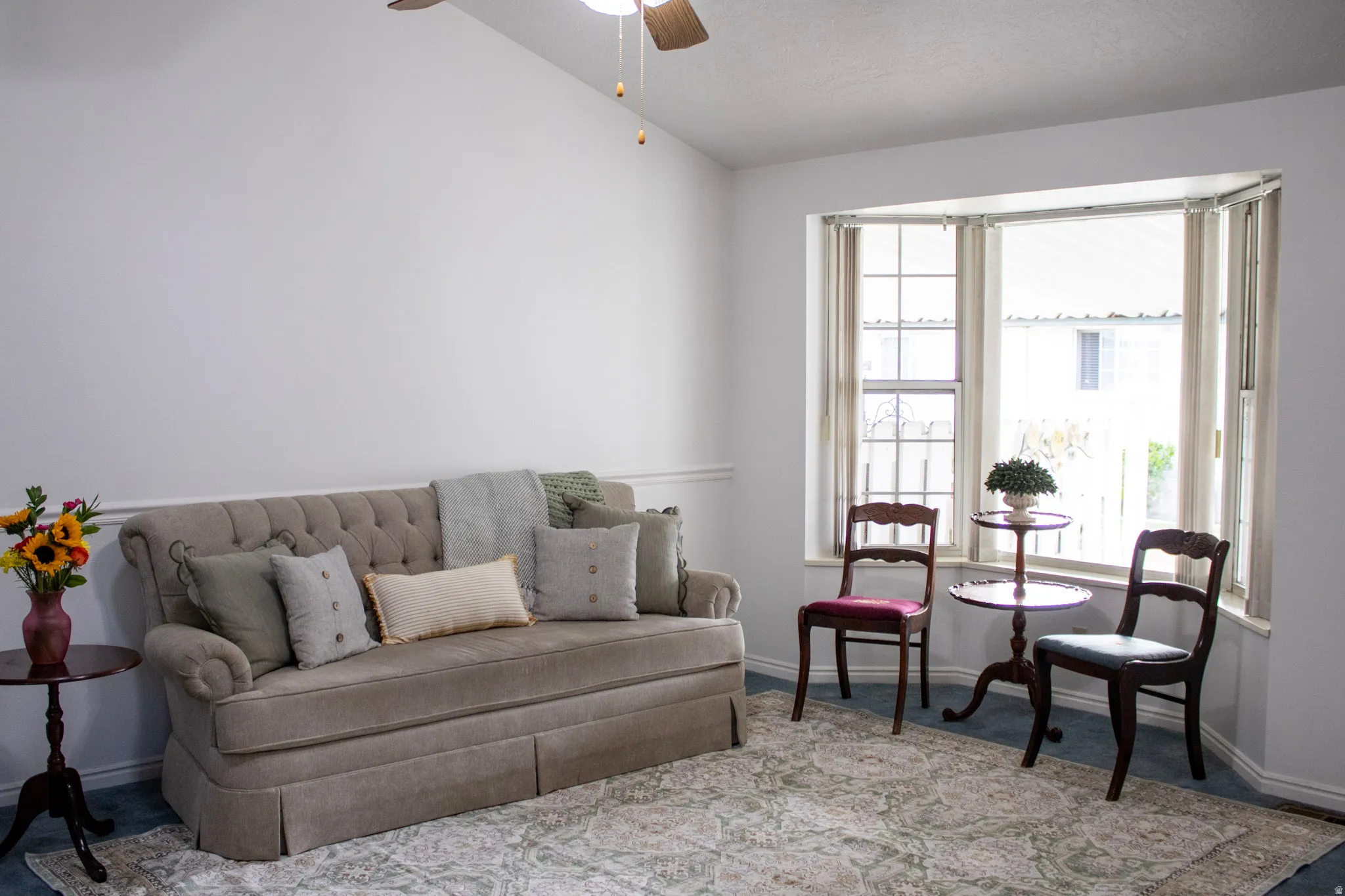 Living room featuring vaulted ceiling, skylight, bay window and ceiling fan