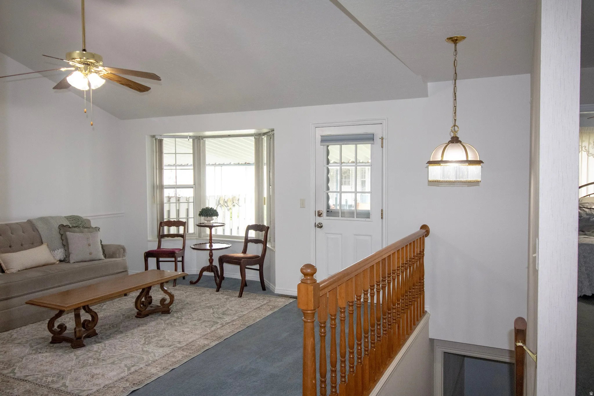 Living room featuring vaulted ceiling, skylight, bay window and ceiling fan